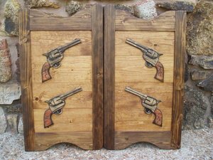 Western saloon door with carved six shooter pistols