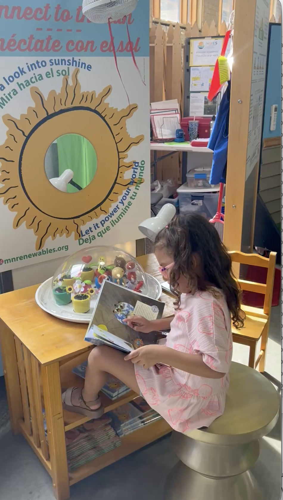 Girl reading book at solar toys.png