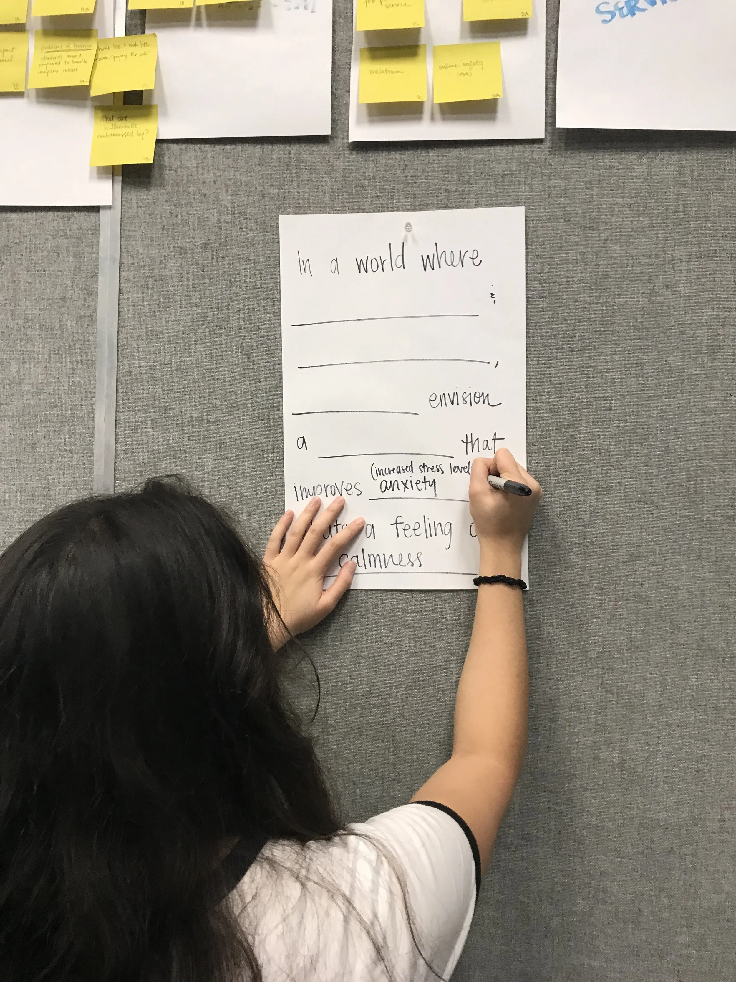 My teammate writing out what we came up with during a design friction exercise.