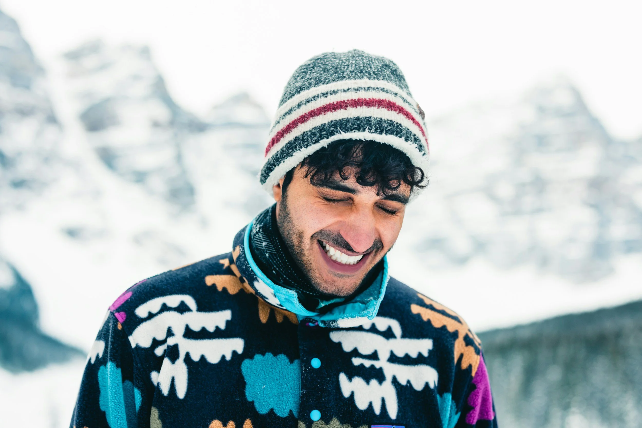 a man, laughing in the snow, radiating joy, despite the cold