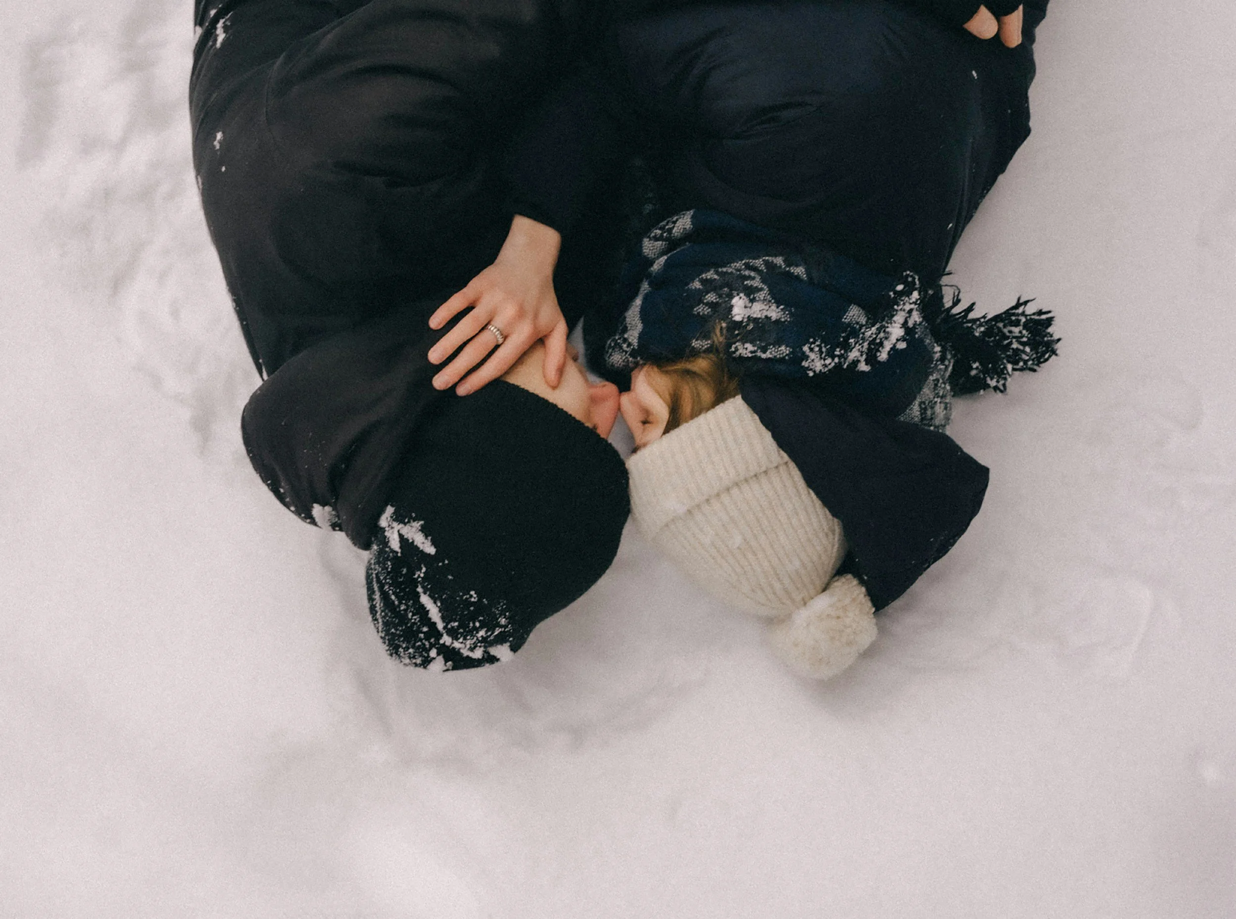 a couple bundled up and romantically close in the snow