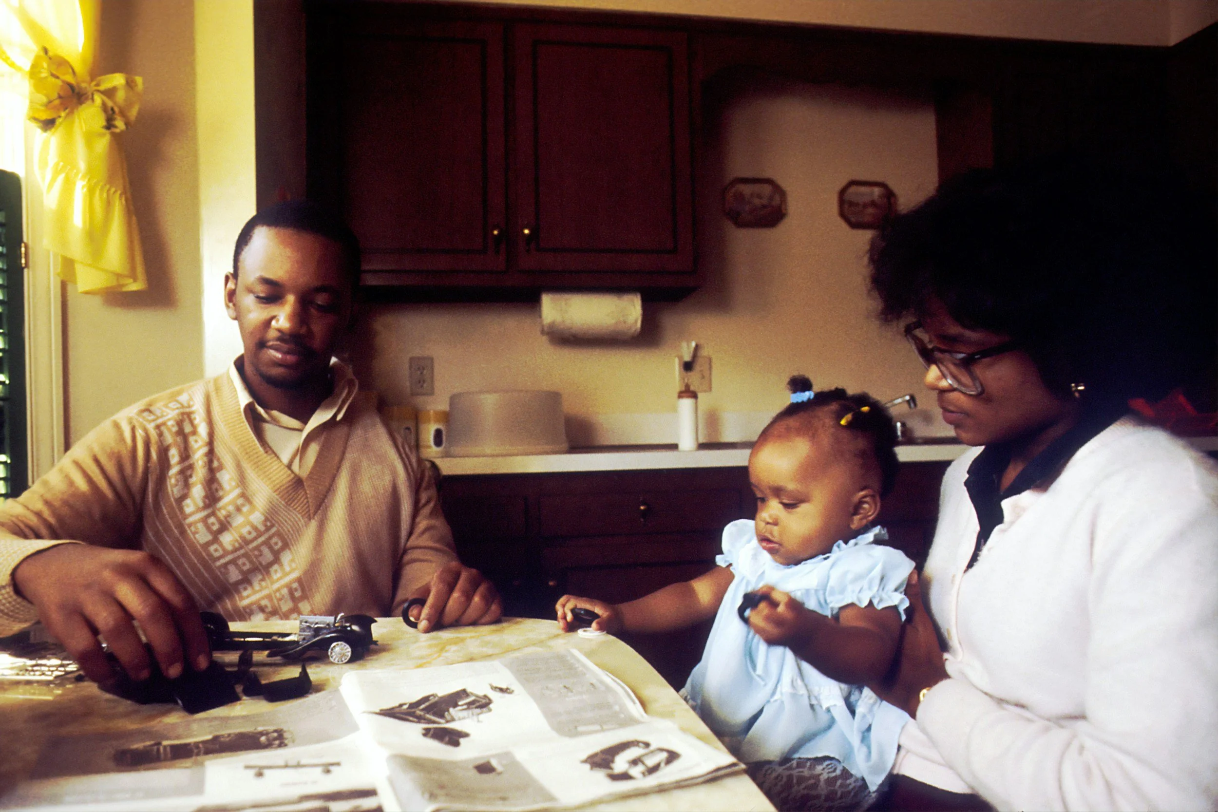 family sits around the dining table engaged in an activity together, postpartum support can be social, emotional, functional, and tailored to each family's needs. you don't have to navigate this stage alone