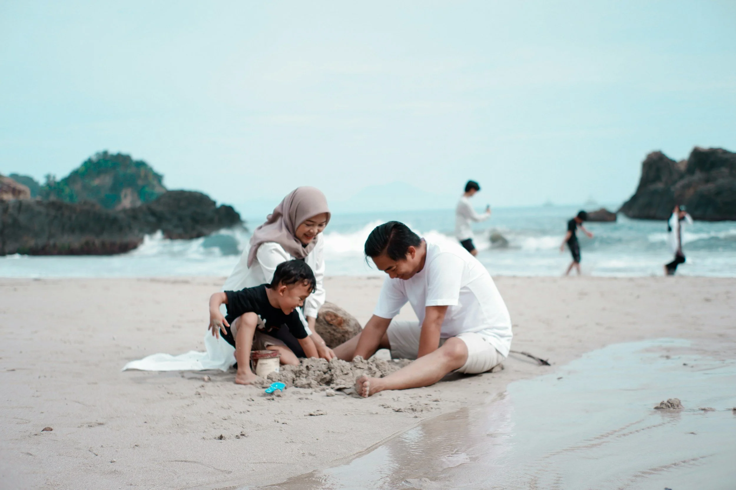 a multiracial family enjoys summertime at the beach, identity-affirming services are available in person in ferndale, michigan and remotely around the state