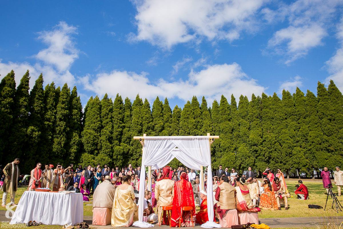 SOP - Arc of Pines - Ceremony consisting of white folding chairs and 4 post bamboo canopy with white chiffon. jpg.jpg