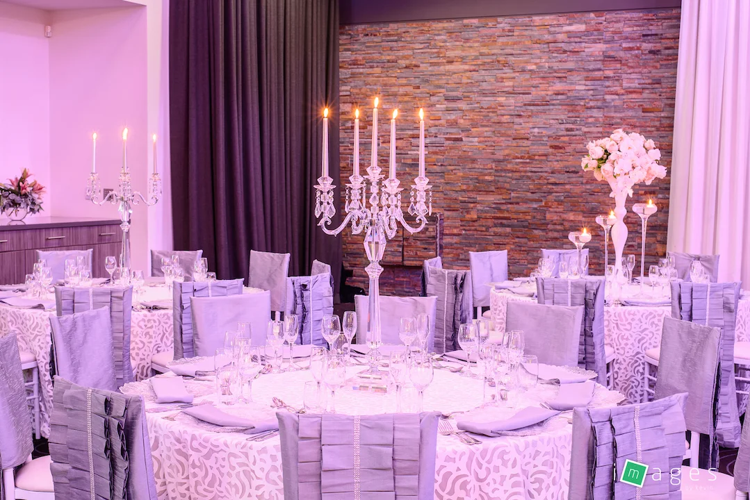 Waterview - Park Room - Guest table centrepiece consisting of medium crystal candelabra, PB White Lori chair caps and Fiori tablecloths, clear glass charger plate with silver napkin.jpg