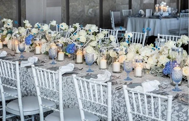 White_anita_blue_underlay_silver_charger_plate_blue_theme_white_tiffany_chair_centrepeice_white_flowers.png