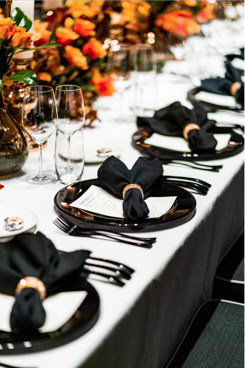 corporate_event_design_events_by_nadia_fresh_flowers_orange_inlighten_photography_black_charger_plate_cutlery_candle_stick_gold_napkin_ring_menu_cystal_glasswear.png