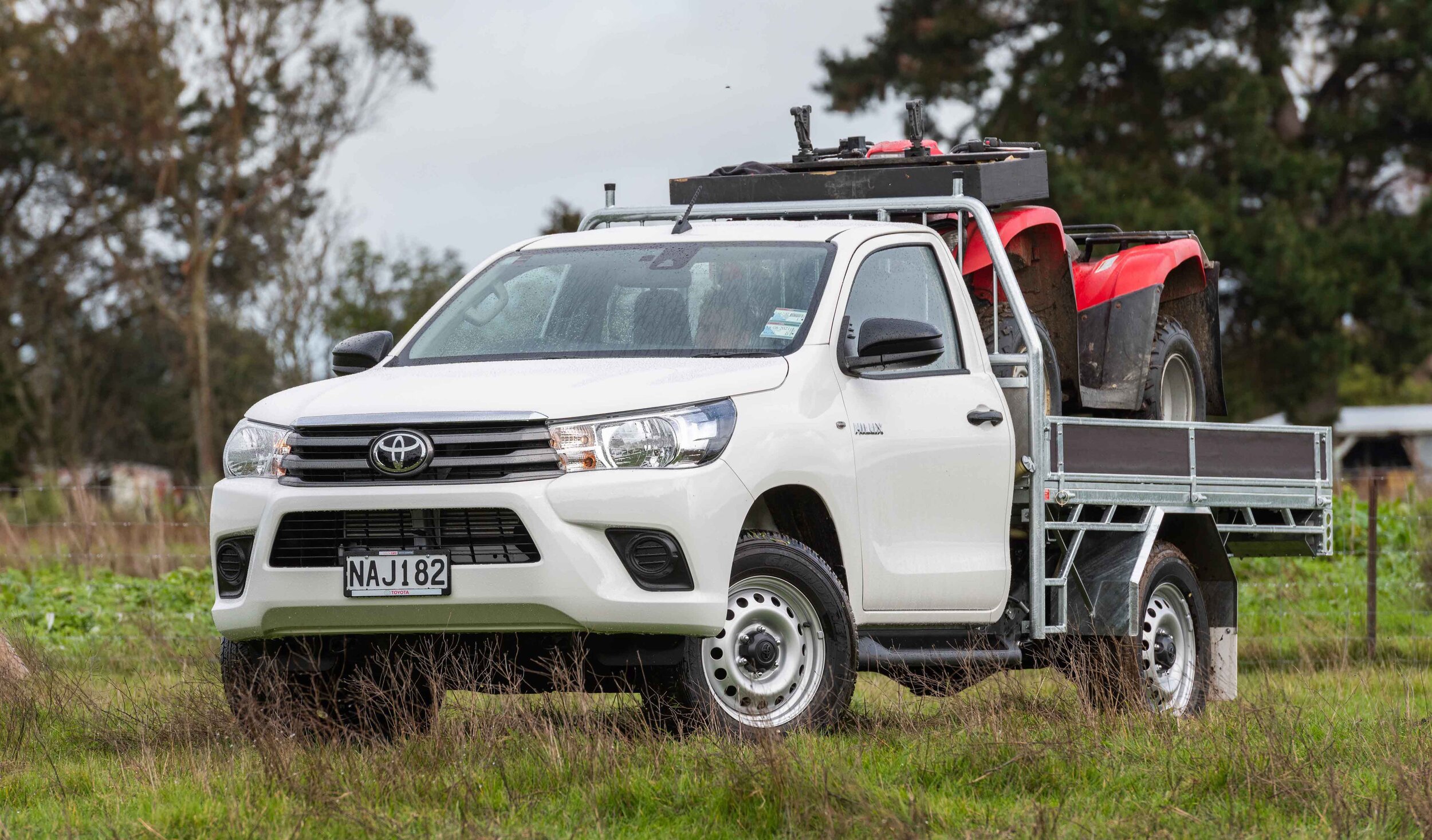 IMAGE_2021 Toyota Hilux SR grade single cab chassis with steel and timber tray, glacier white, front three quarter farm shot.jpg
