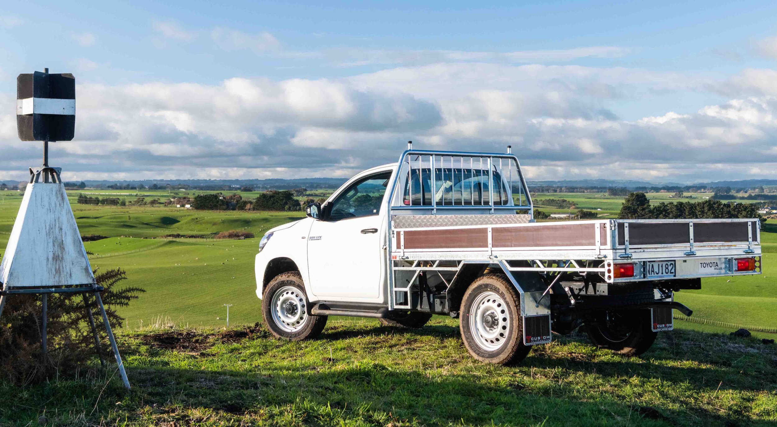 IMAGE_2021 Toyota Hilux SR grade single cab chassis with steel and timber tray, glacier white, rear three quarter farm shot.jpg