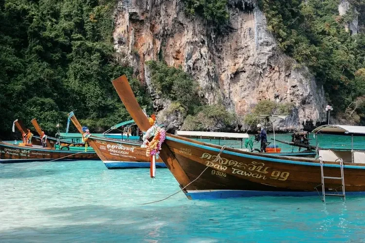 Long-thail-boats-beach-thailand.webp