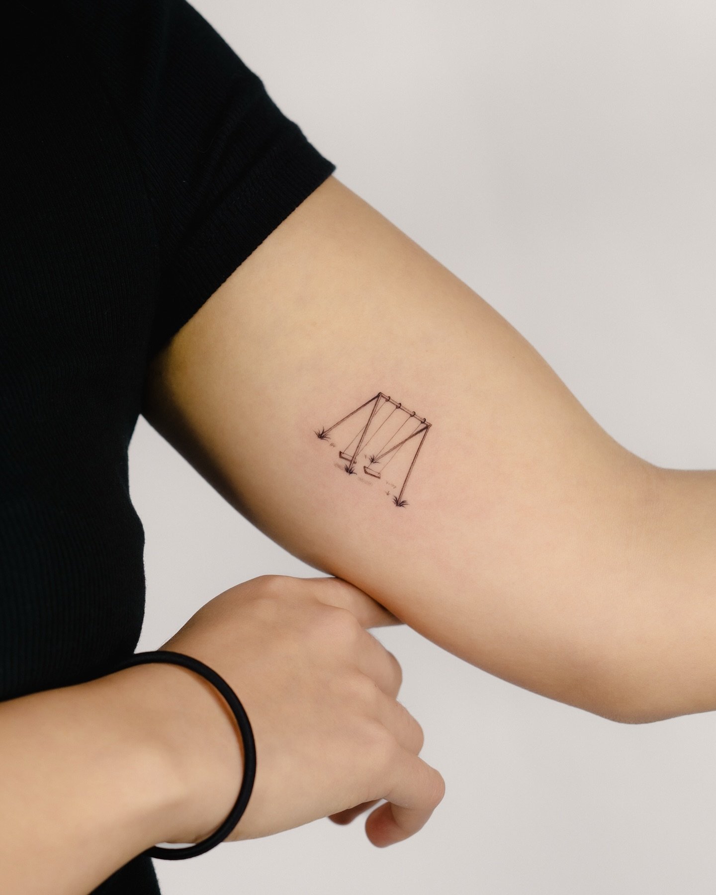 A swing set tattoo in loving memory of her late grandmother. It was a privilege to bring this sentimental piece to life as her first tattoo&mdash;thank you for trusting me with something so meaningful. Fingers crossed her mom isn&rsquo;t too upset ab