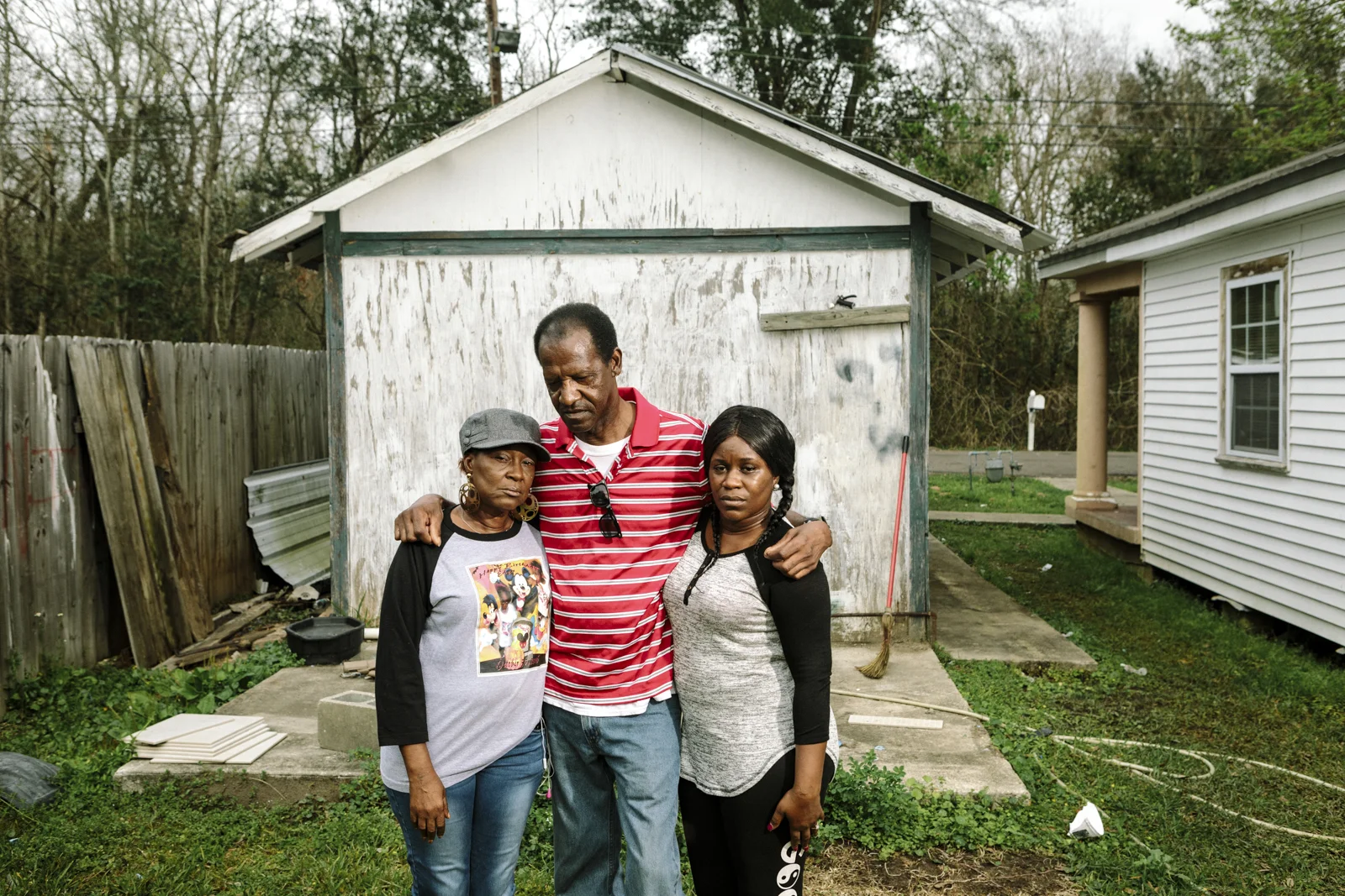 Reserve, LA - Feb 20, 2017 - David Sanders (59) stands with his wife Laverne Sanders (59, L) and daughter Shannon Perrilloux (35) in the back yard of their home on East 31st Street, which borders the fence line of the Dupont/Denka plant.