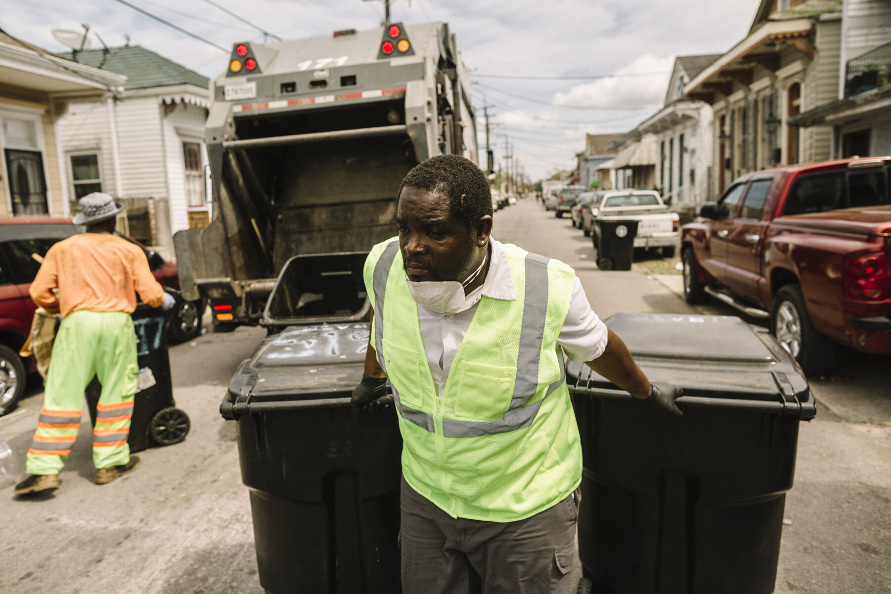  New Orleans, LA - March 24, 2020 - Isaac Brooks works with fellow employees to load residential trash into the back of a Metro Services Group garbage truck. The company has begun furnishing extra protective equipment to their employees in an effort 