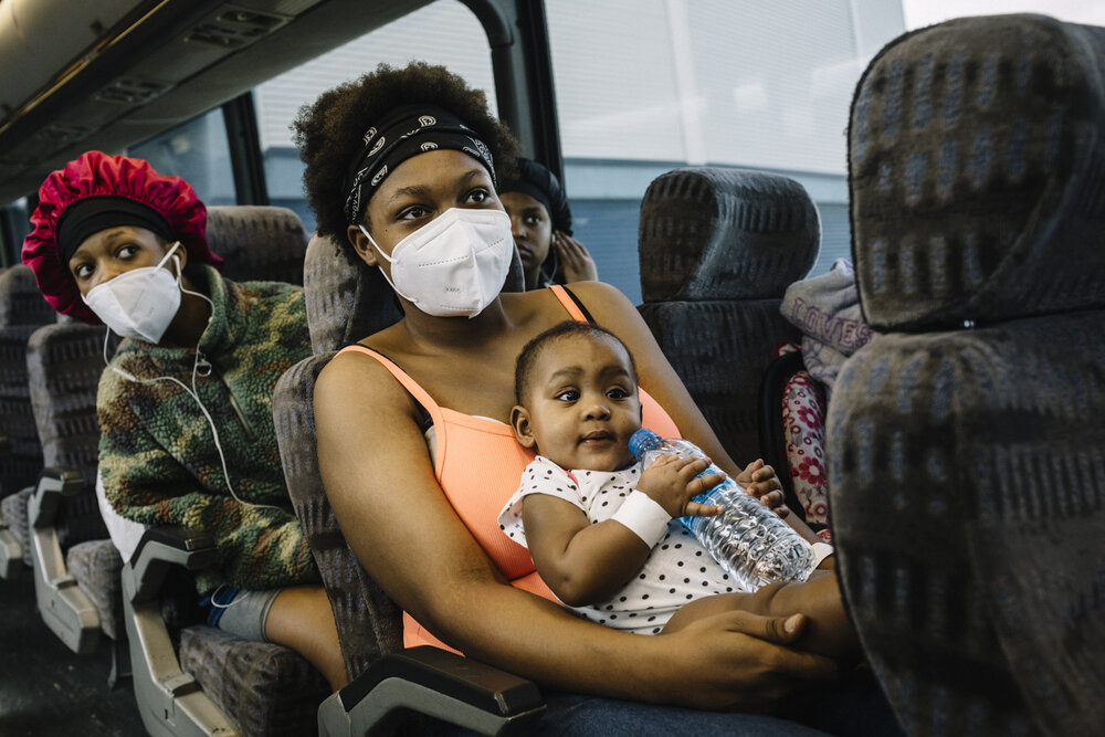  NYTSTORM - Lake Charles, LA - August 26, 2020 - Renee Allred (19, center) and her family settle into a coach bus bound for Baton Rouge. Local residents gathered at the Burton Complex, an event center in Lake Charles, for assisted evacuation. The cit