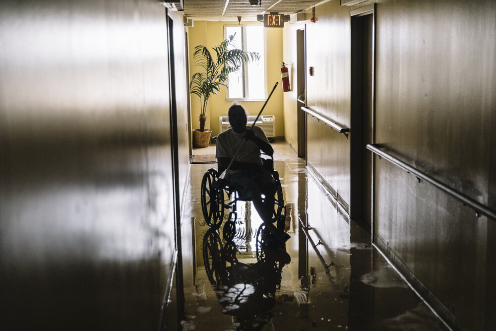  NYTSTORM - Lake Charles, LA - August 27, 2020 - Lincoln Cole (64)  attempts to mop water from his apartment and the hallway in Chateau Du Lac, an eight story residential building near downtown Lake Charles that sustained massive damage in the previo