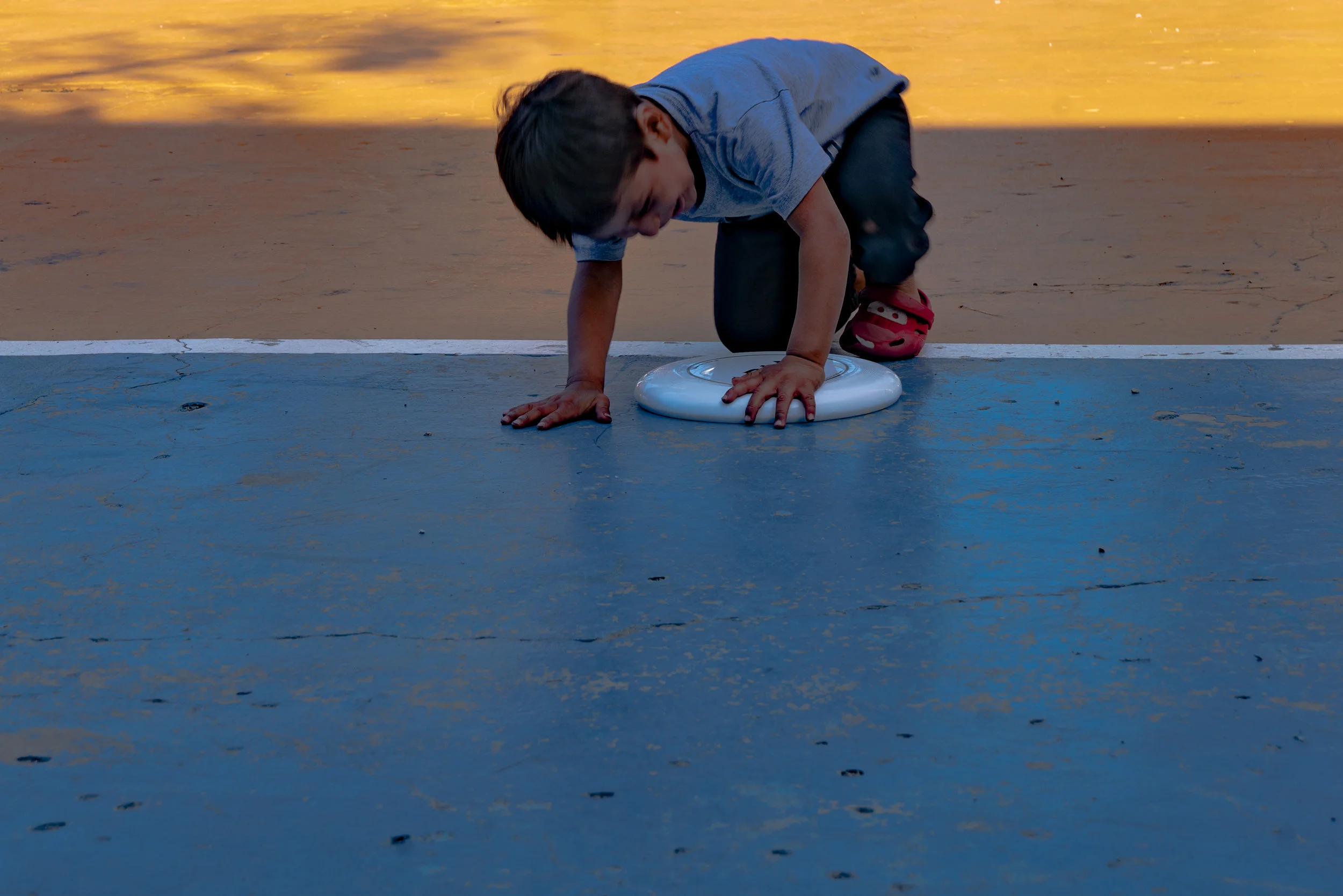 A young boy plays with a Frisbee at a park by the refugee shelter that we visited.