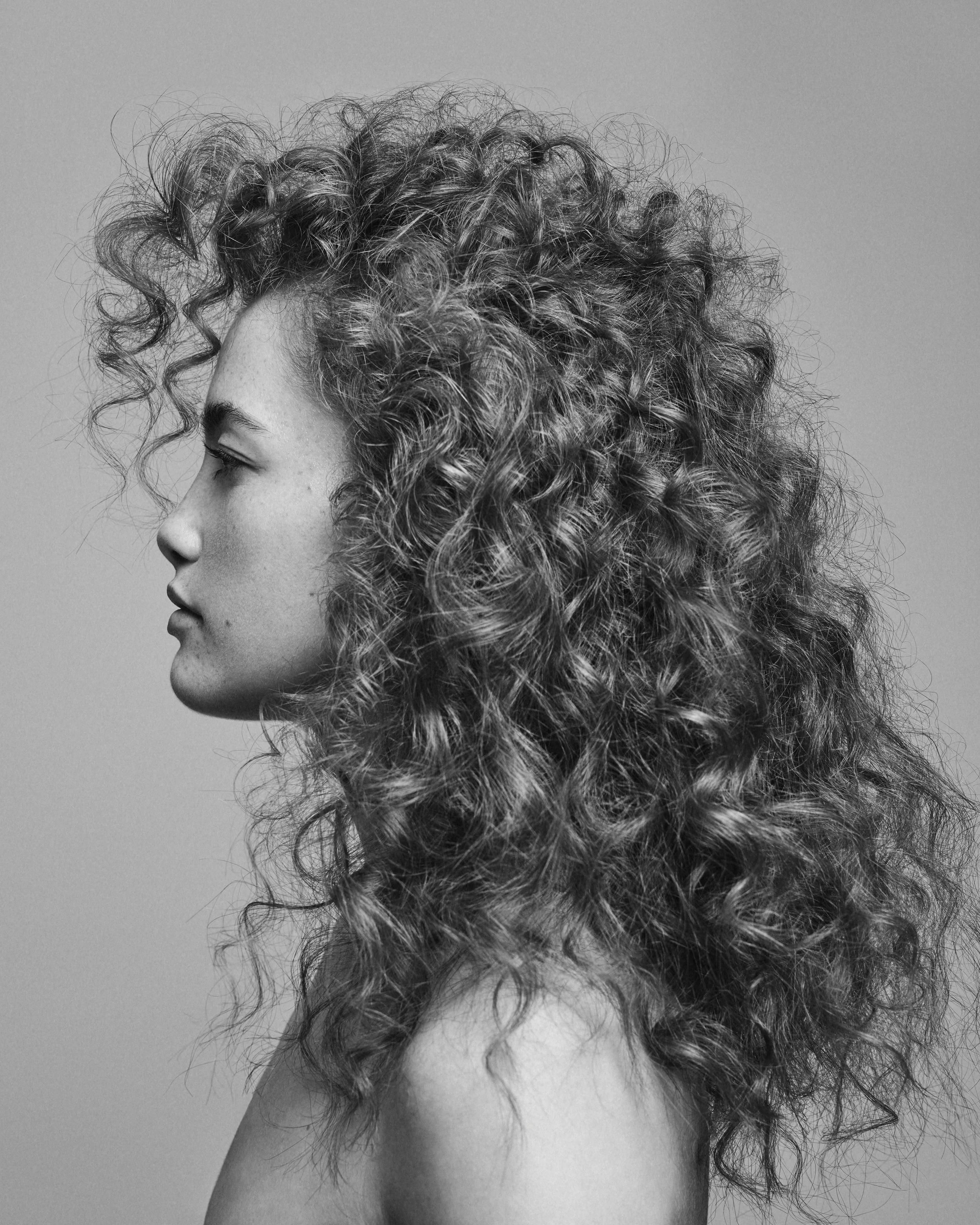 A side profile of a woman with curly hair