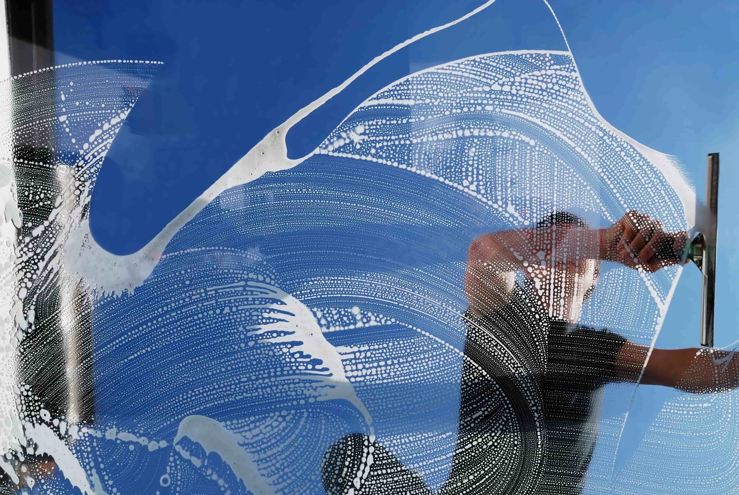 Window cleaner squeegeeing in Bend