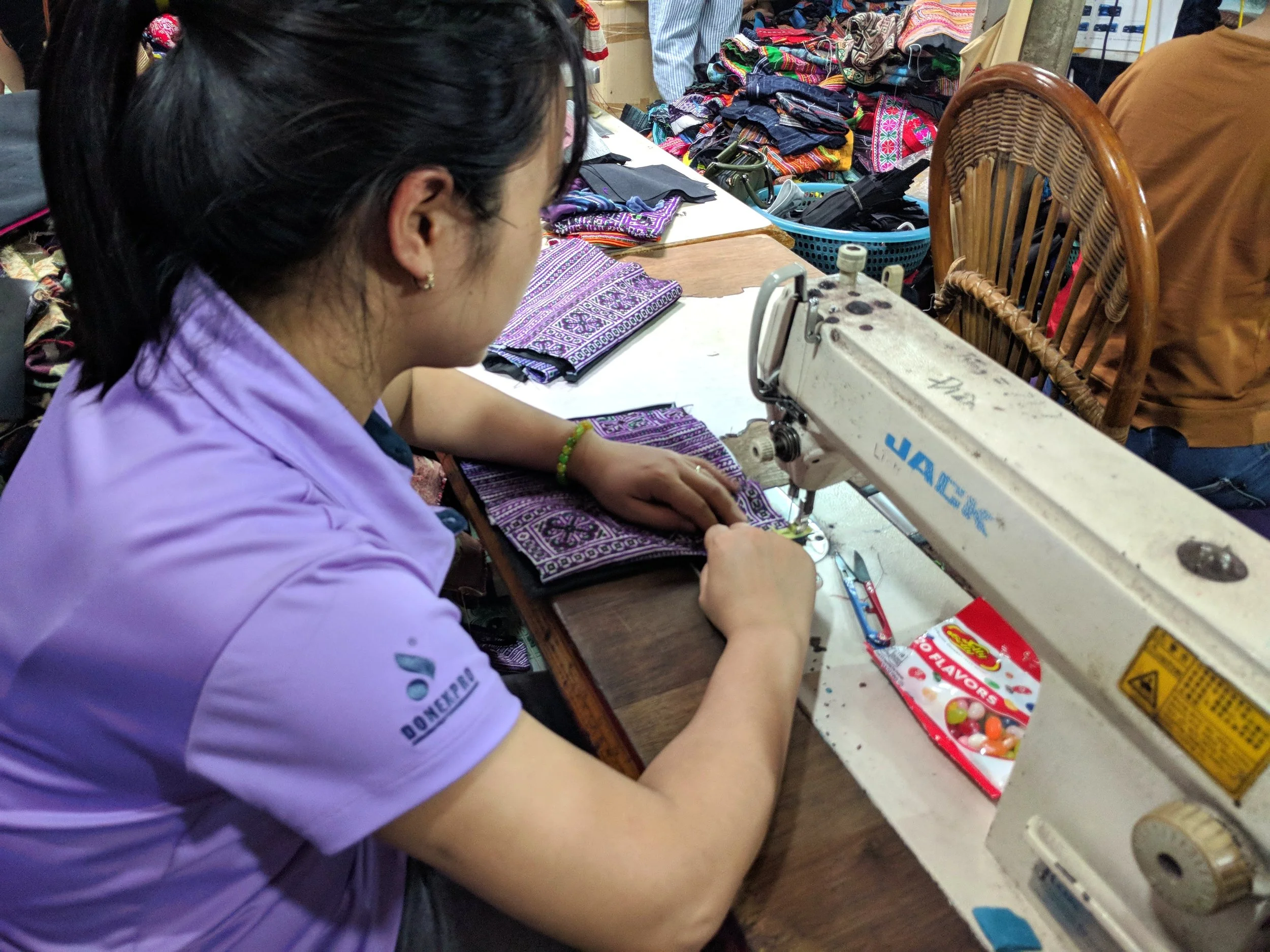 Hien’s employee, Lien, sews a zippered pouch. This job has provided her with steady work for over 8 years.