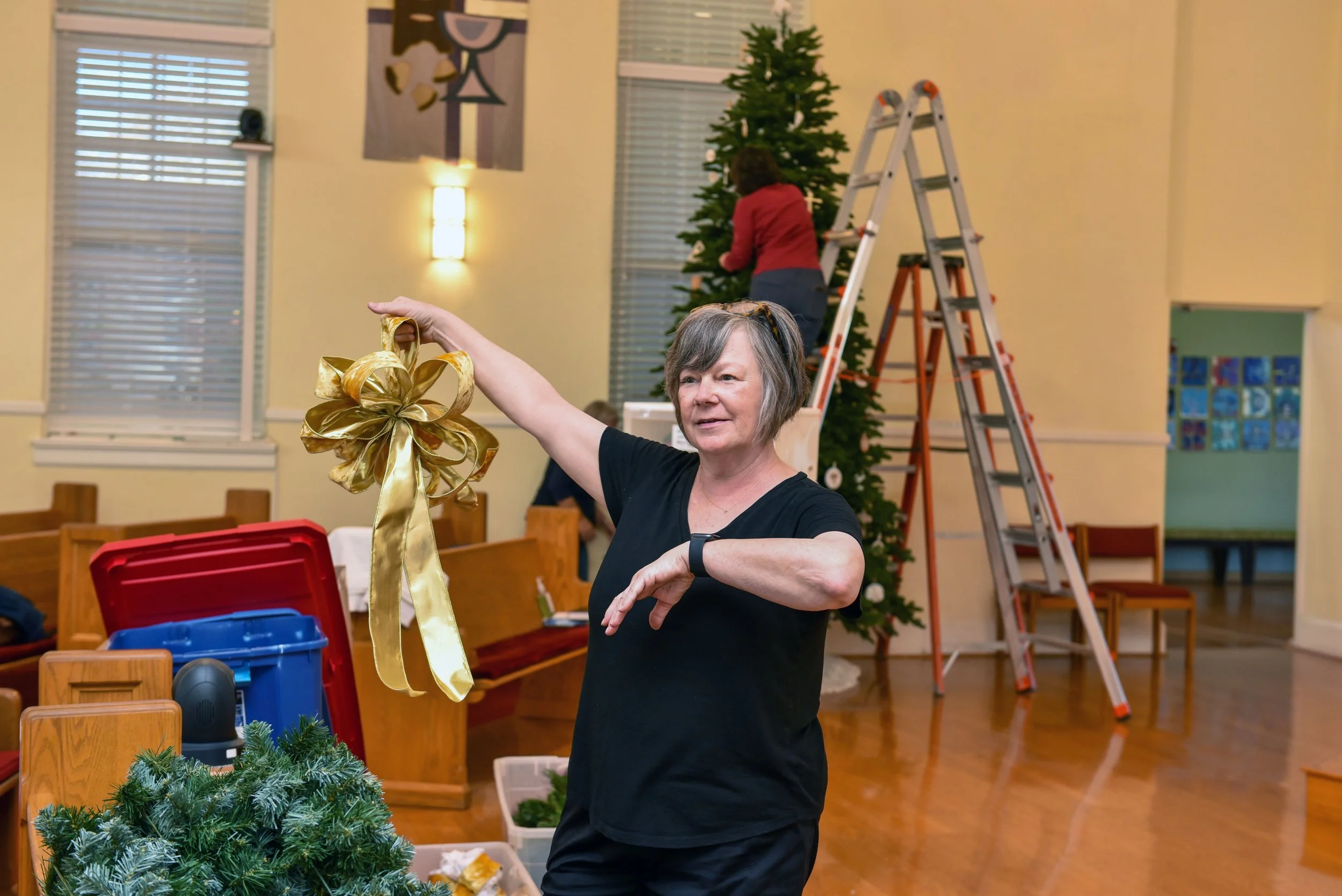  Cindy Chapman unpacks gold bows, showing them to other volunteers. 