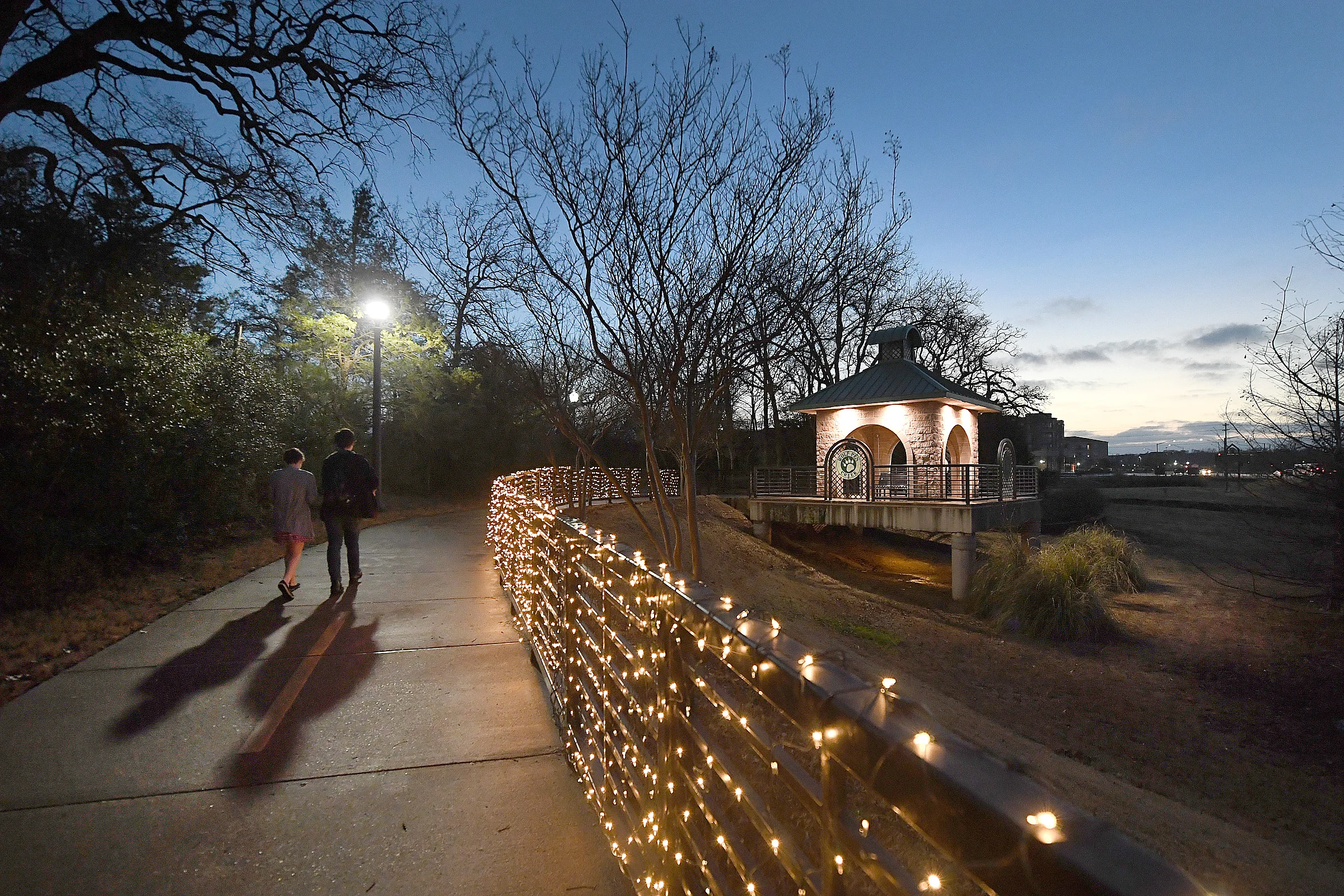 Dalanie Ward and Joseph Wise walk the Trail of Lights at Wolf Pen Creek Park in College Station, Texas, during a Wednesday, Feb. 14, 2018 date night event that included food trucks, live music and horse-drawn carriage rides. (Laura McKenzie/The Eagle)