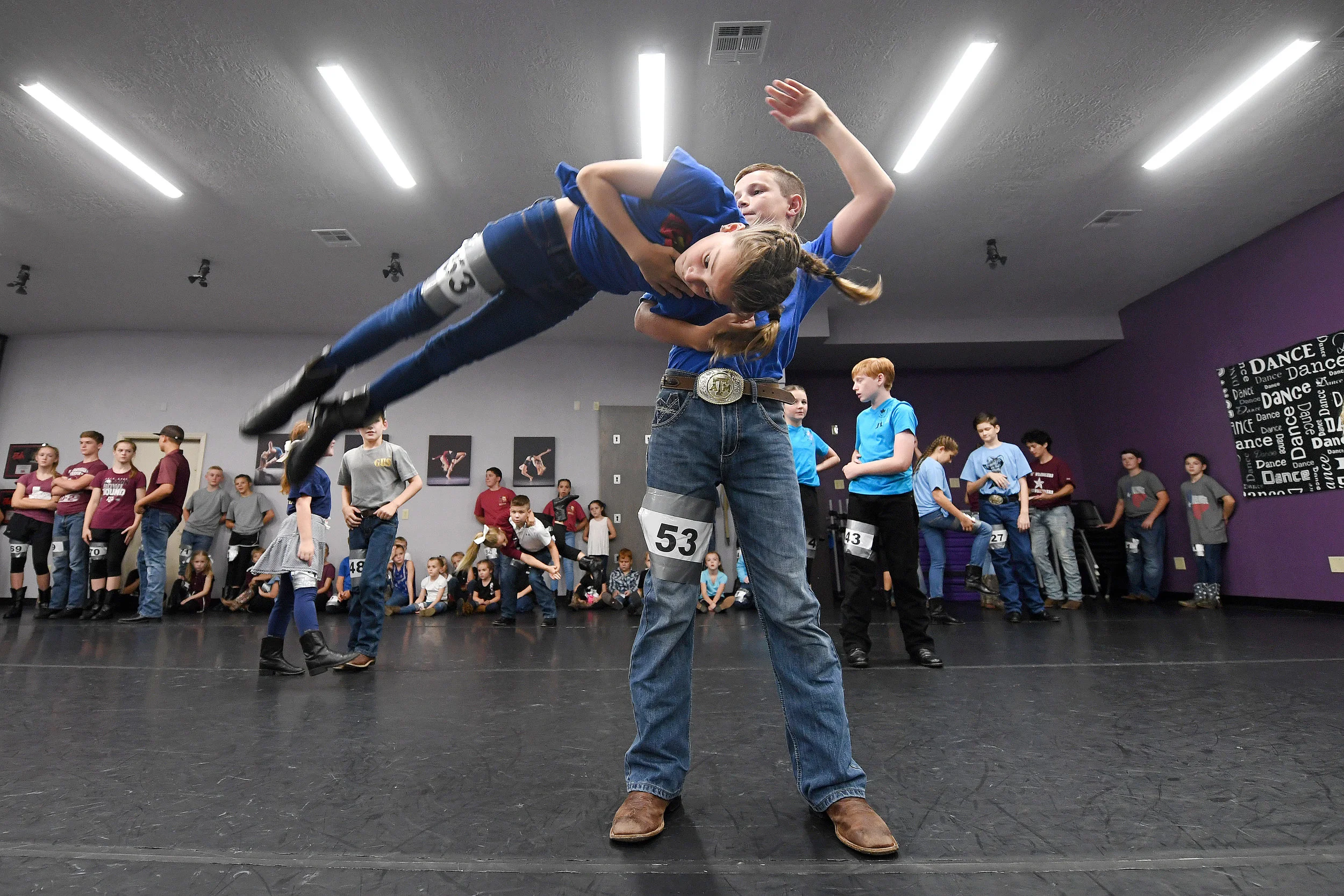Grayson Coker, 13, swings his partner Allie Fleener, 11, in the air during the Lil' Wranglers audition at Expressions Dance and Music on Saturday, July 21, 2018, in College Station, Texas. (Laura McKenzie/The Eagle)