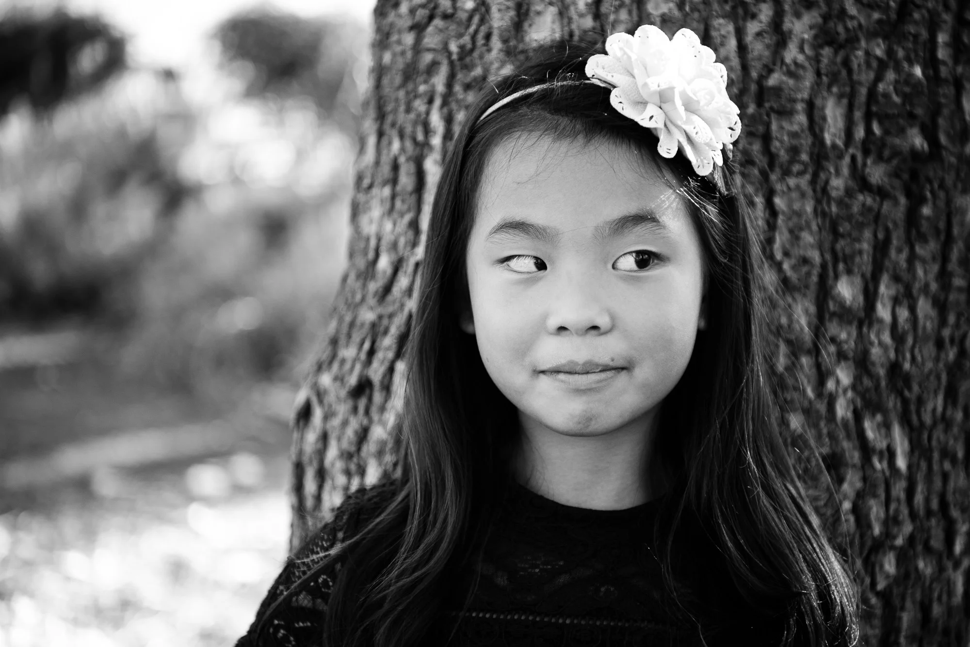 Little girl with bow in her hair in front of a cedar tree in Cedar Grove Park in Tustin, California. Full post at lisahuchen.com.