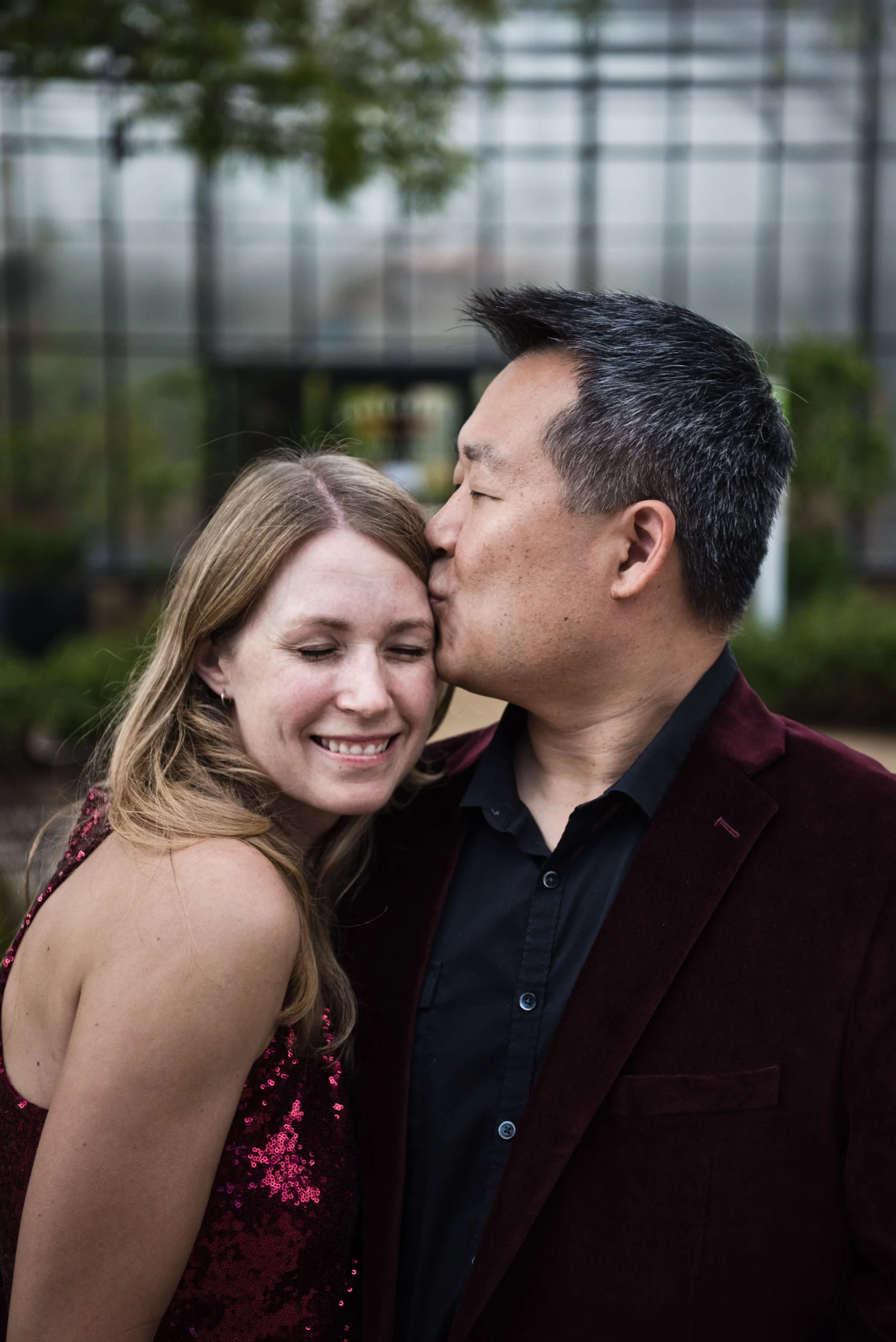 Dad kissing mom as mom is smiling. Pavilion Park in Irvine, California.