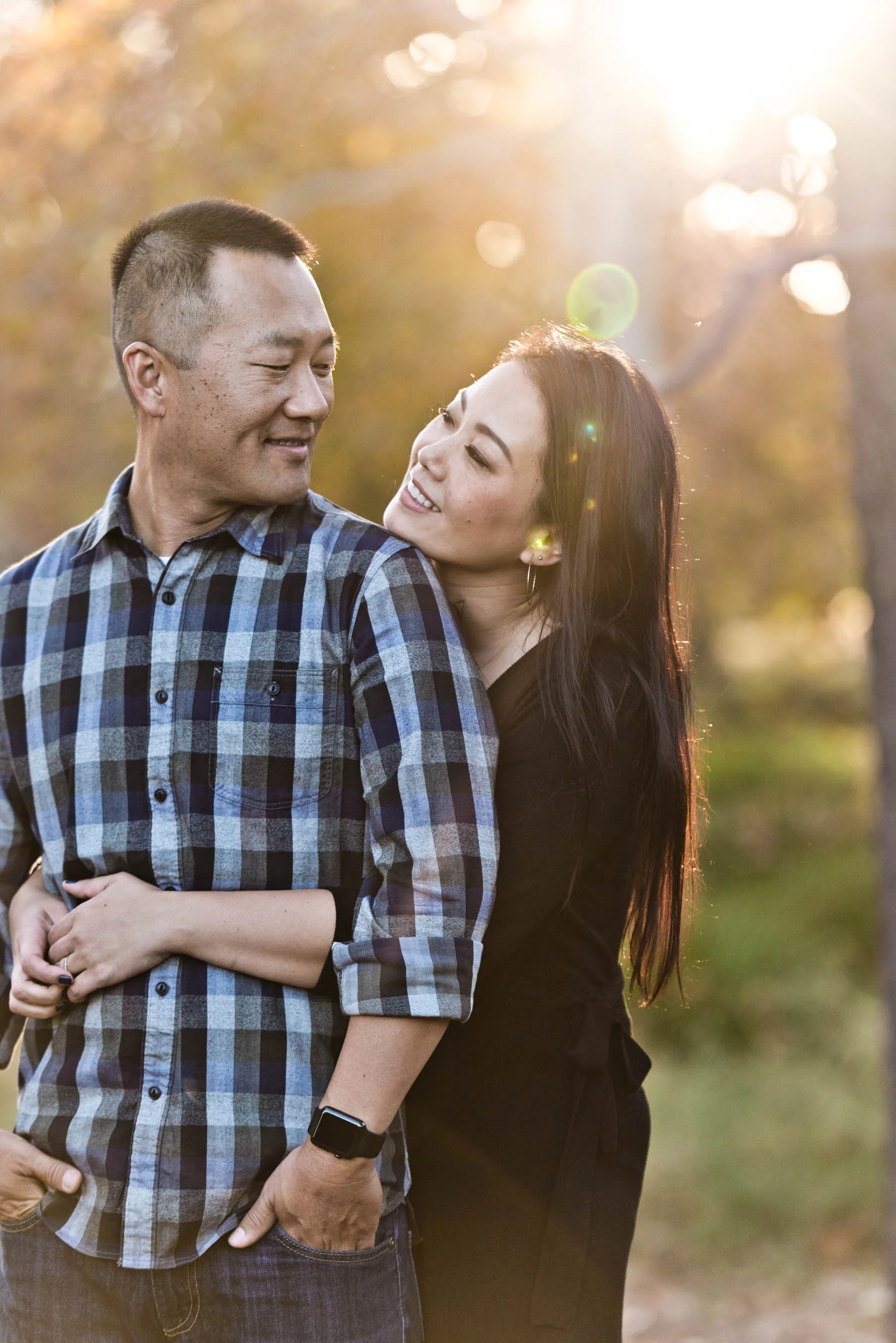 Asian couple. Mom holding dad and looking into each other's eyes in the park. 