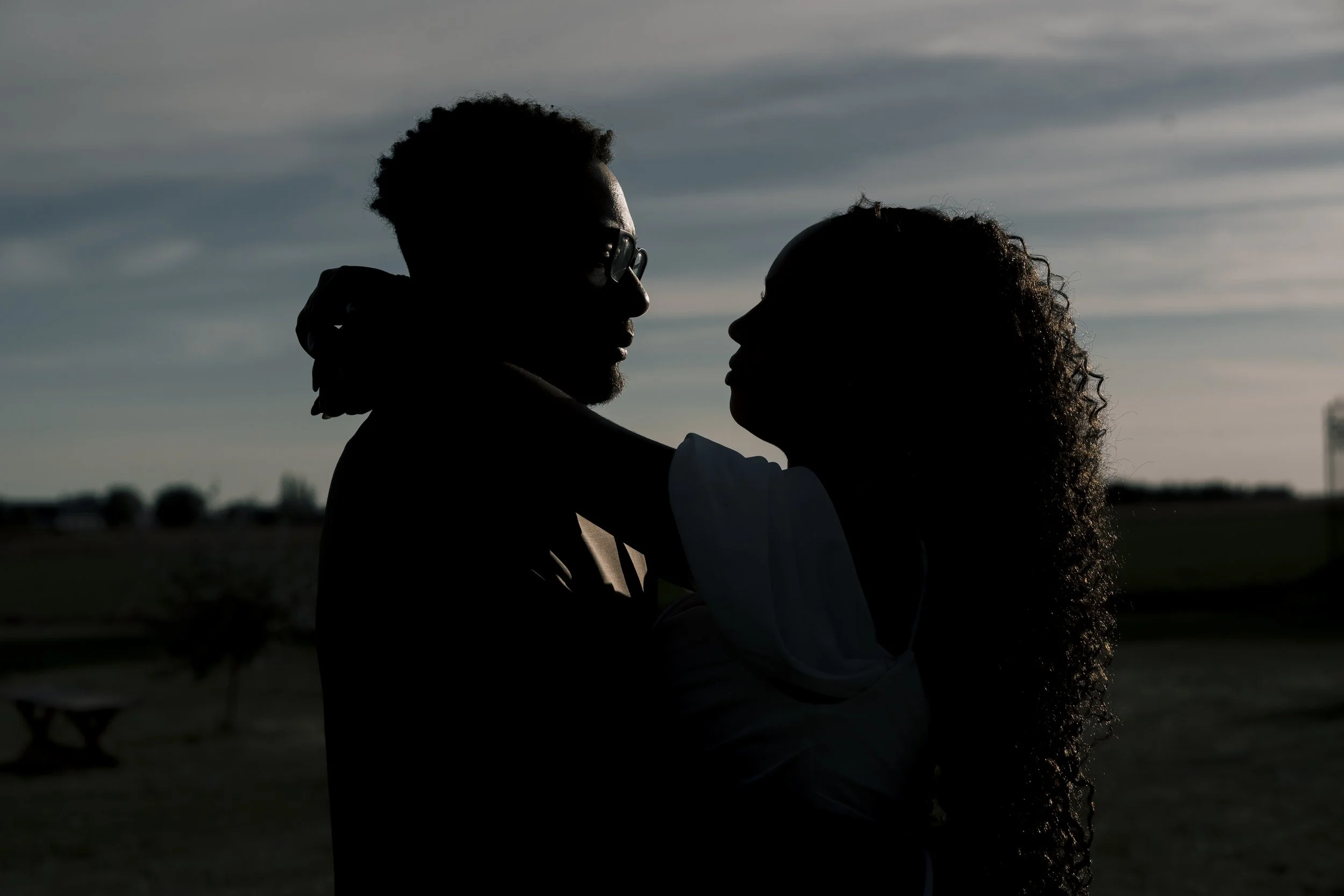 Tegenlicht tijdens trouwfeest met bruid en bruidegom in beweging, warme gloed en spontane emoties op de dansvloe