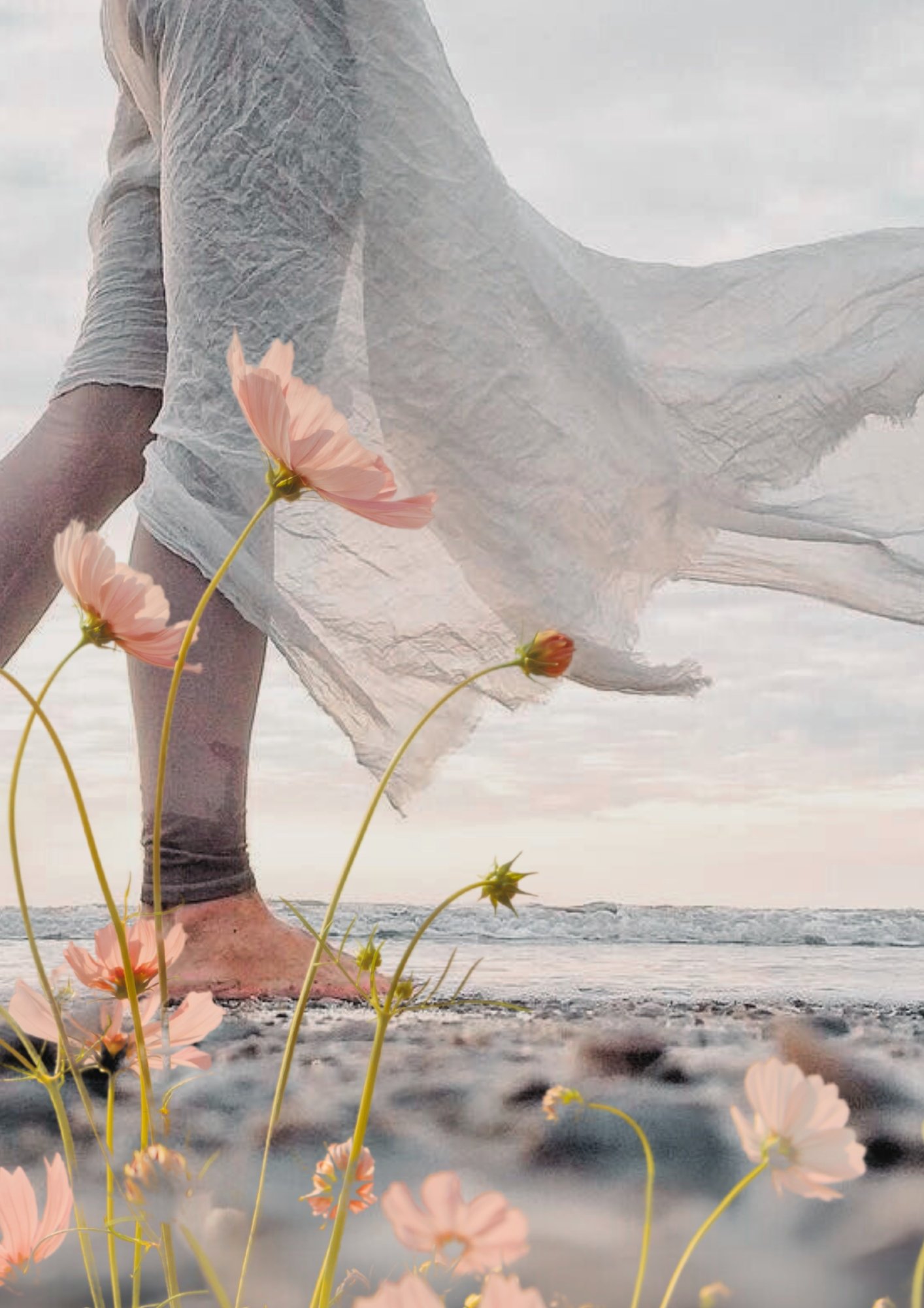 Person walking barefoot on the beach with pink flowers and a flowing white dress, ocean in the background at sunset.