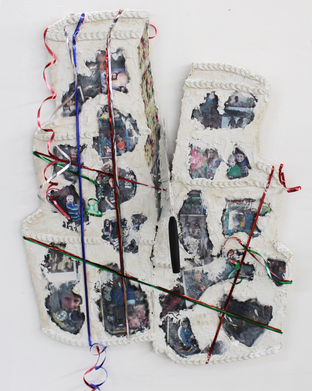 A mixed media artwork with ribbons cast into a 3D surface covered in image transfers