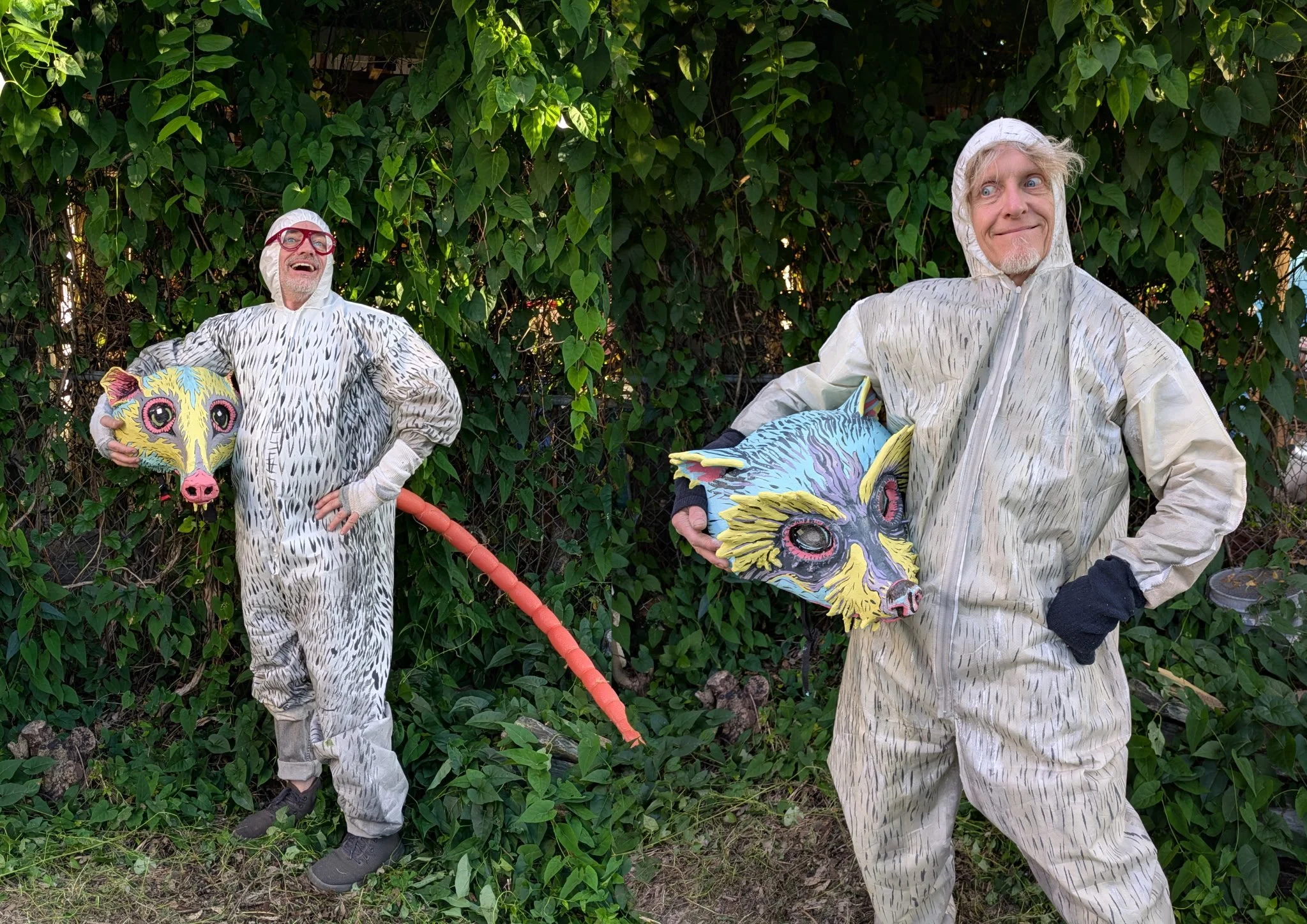 Two artists trapse amont the vines wearing vermin costumes complete with painted fur and colorful rat heads and tails