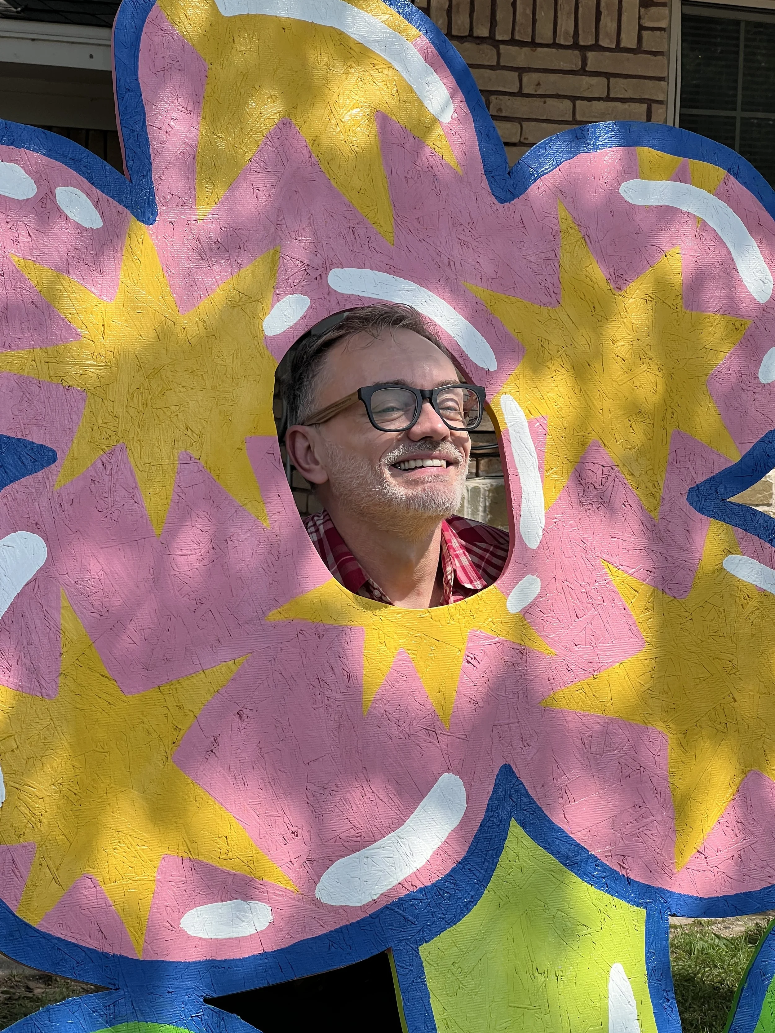 Brian smiles in the middle of a large scale painted flower by Anna Galluzzi