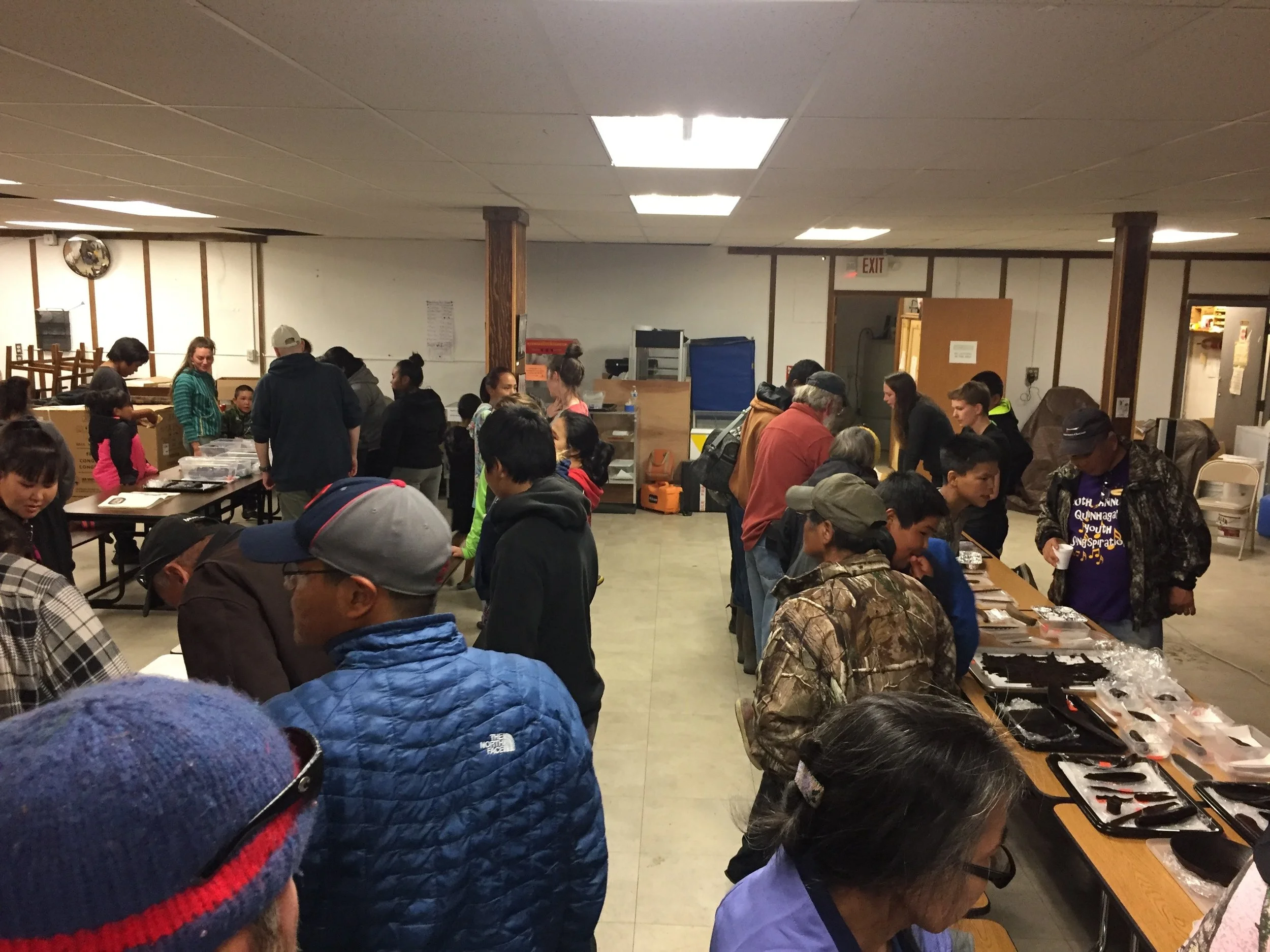 Sharing the objects with the community of Quinhagak. Items are left out for people to inspect and engage with the objects. Each table was divided into like items.