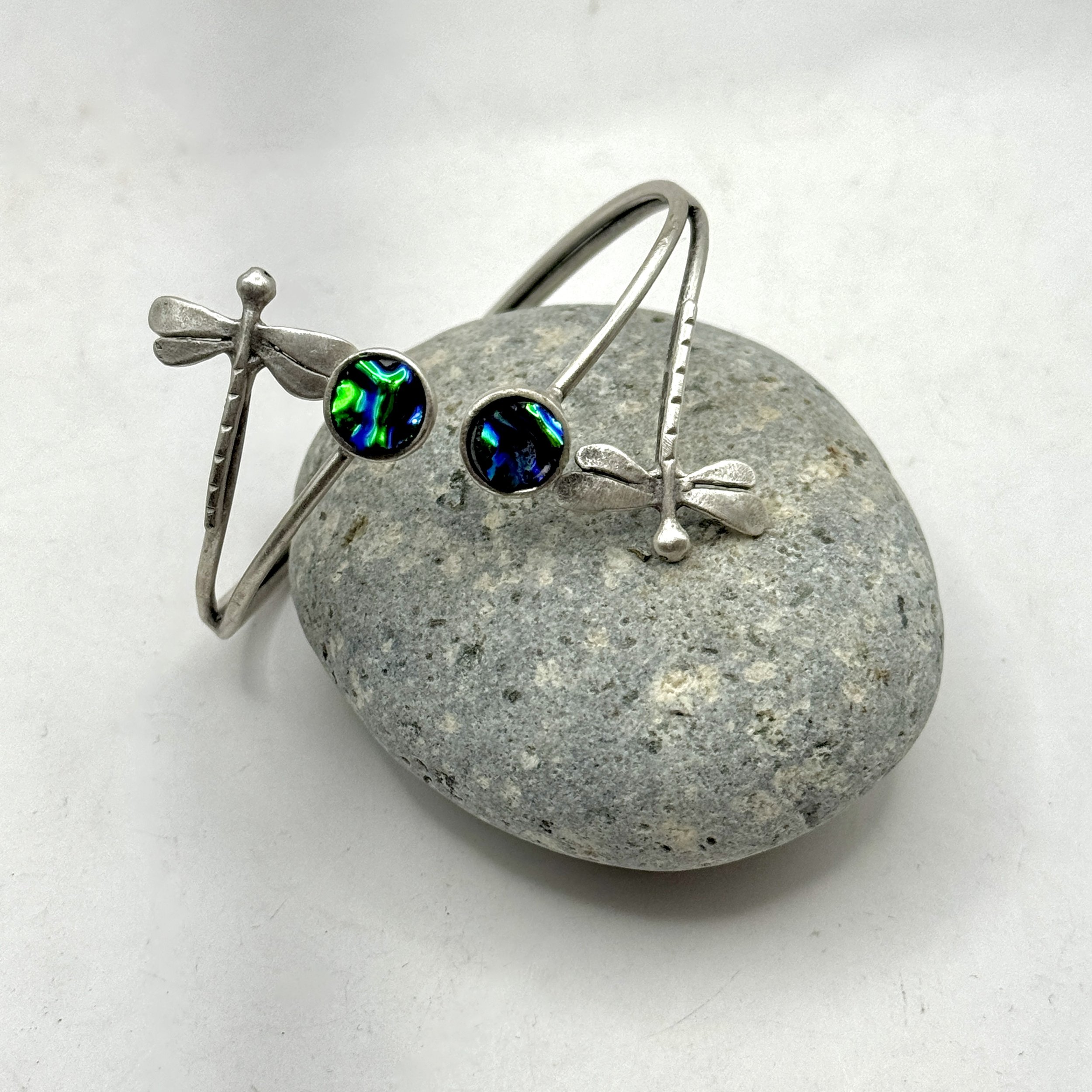 Double dragonfly adjustable silver plated bracelet with two hand cut circles of blue/green dichroic glass.