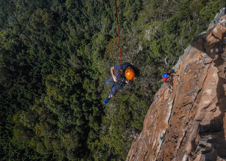 Adam setting up a shot, abseiling off a 150m cliff to get into position. Image: Jake Anderson