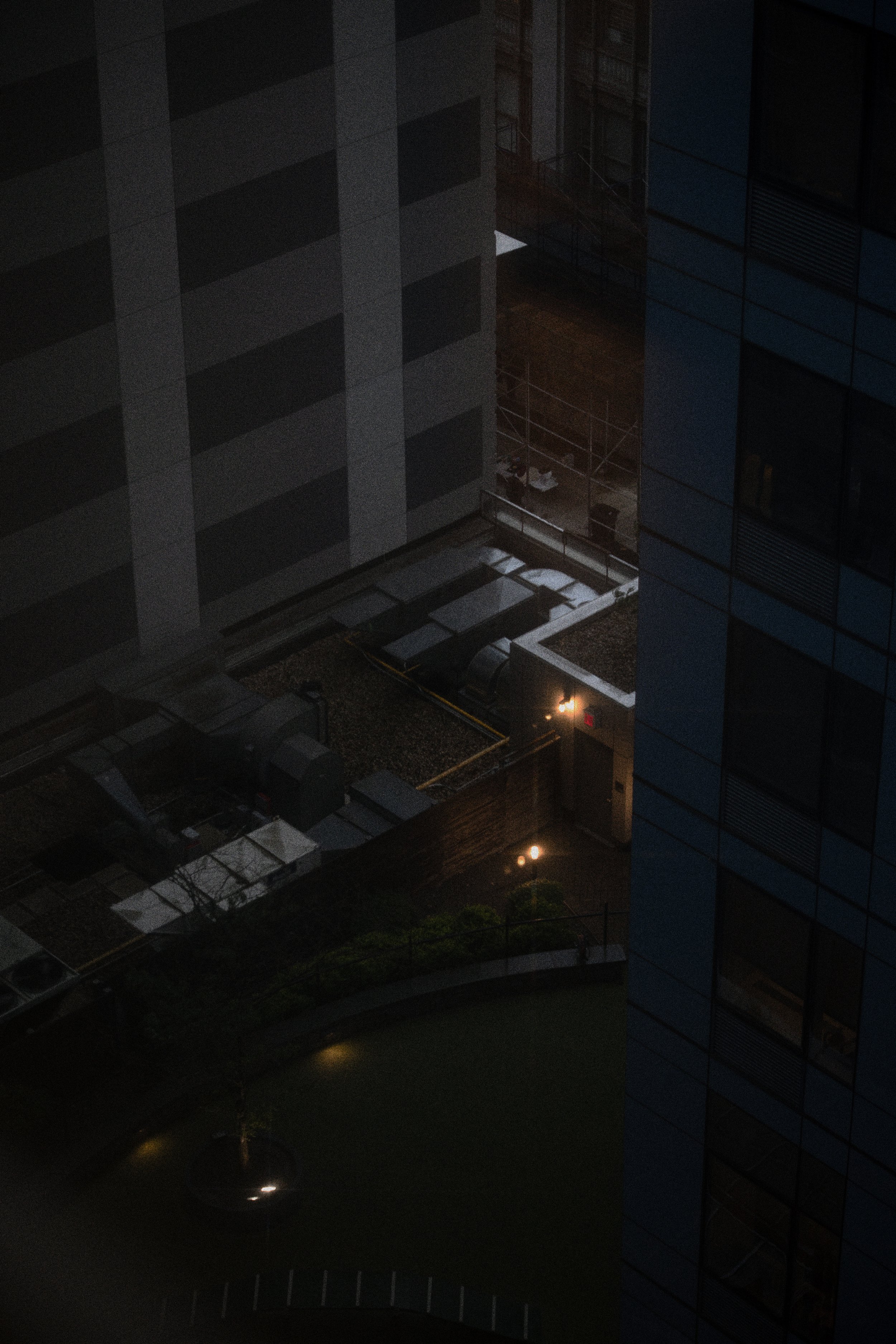 Nighttime view of the rooftop and the exterior of a tall building in a city.
