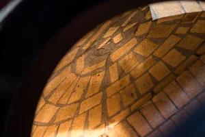 The dome is entirely constructed in whole refractory bricks, furnace baked, with high alumina content and immersed in a refractory cement casting, resistant to temperatures up to 1200°C. The high alumina content permits longer heat retention: when the oven is turned off in the evening, it will still be warm the following day. The bricks also have enough resistance to prolong the life span of the oven up to double that of conventional ovens.