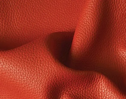 corrected grain leather Leather which has been buffed or sanded to remove surface imperfections before having a surface coating applyed containing pigment . An artificial grain pattern is usually embossed into the surface .