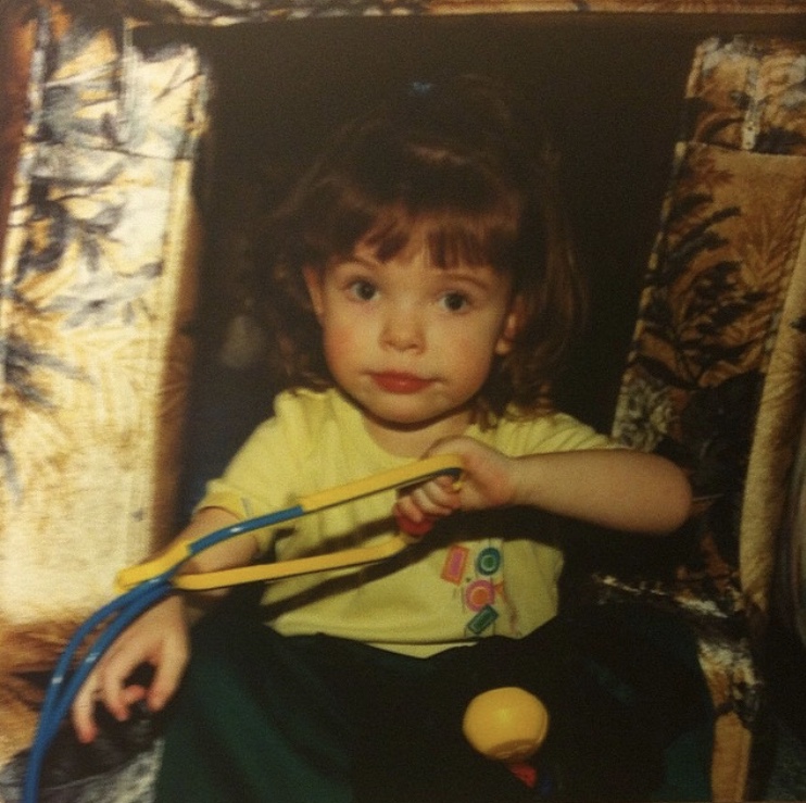 Lauren at approximately three years old, holding a toy stethoscope.