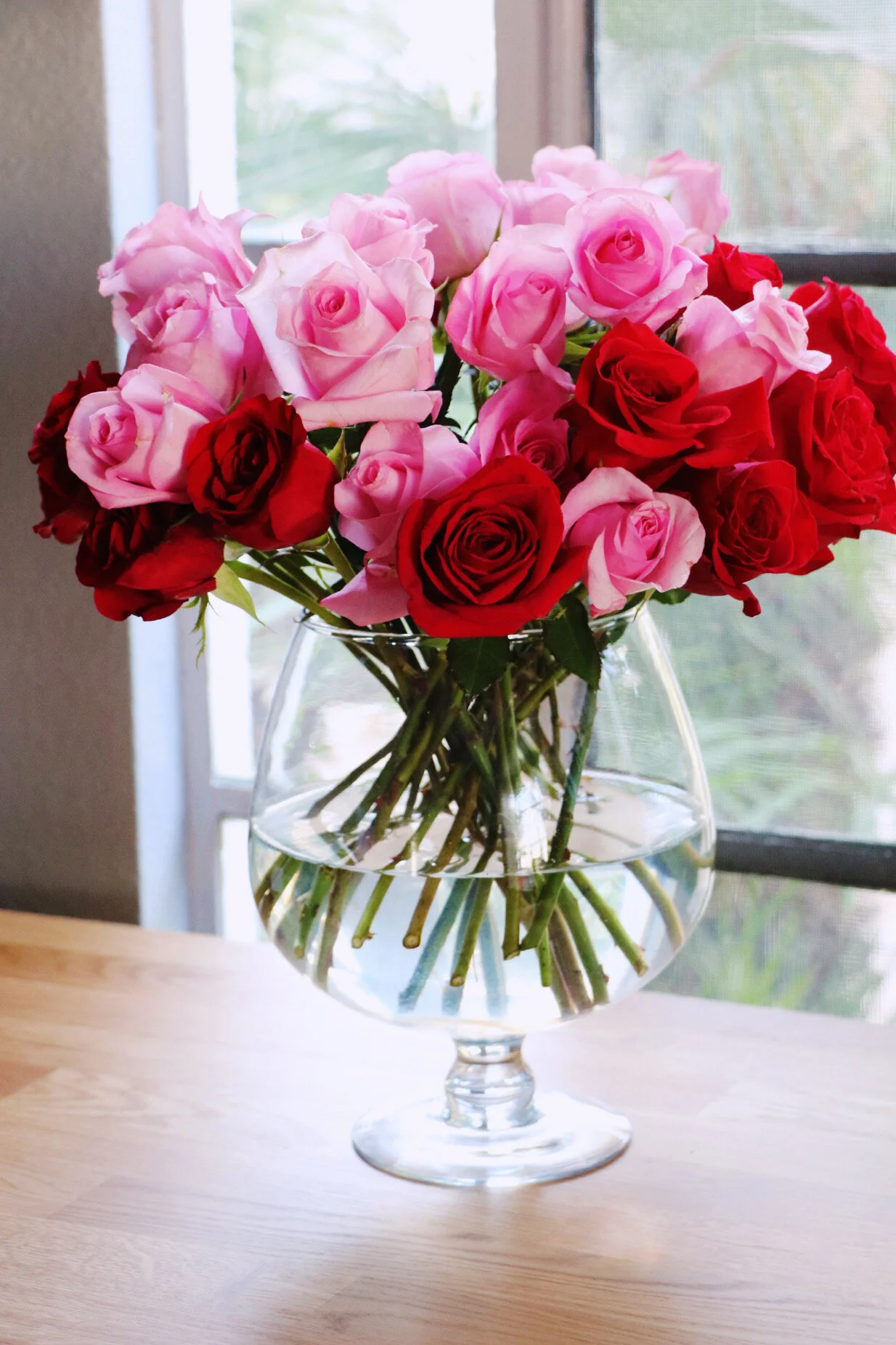 Pink and red roses on a desk in a home office