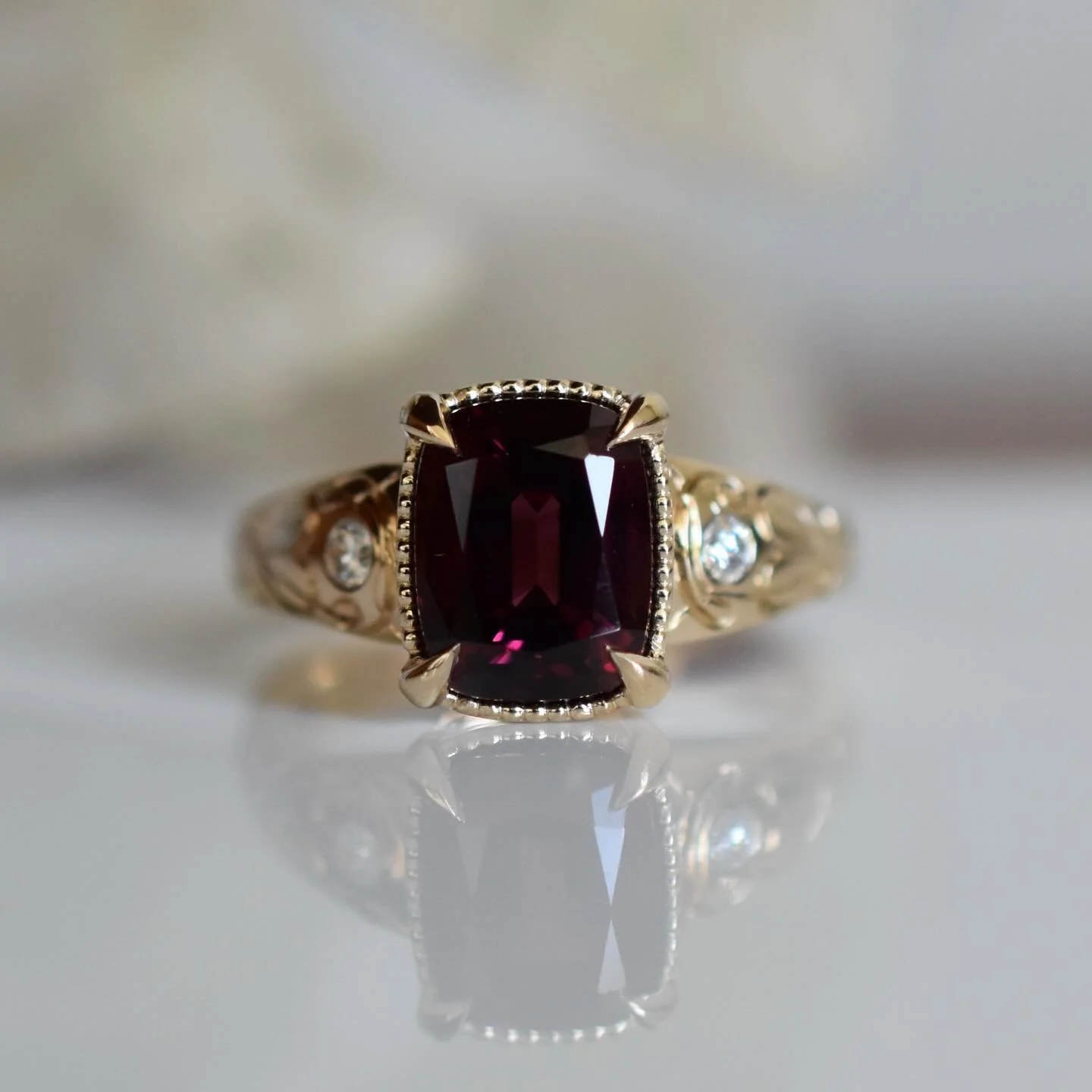Brand new 14k gold and Rhodolite Garnet ring. Embellished with hand engraving of my custom Art Nouveau pattern. This garnet was custom cut in Germany and I chose not only for its cutting, but its beautiful rich colour. 
She is available and ready to 
