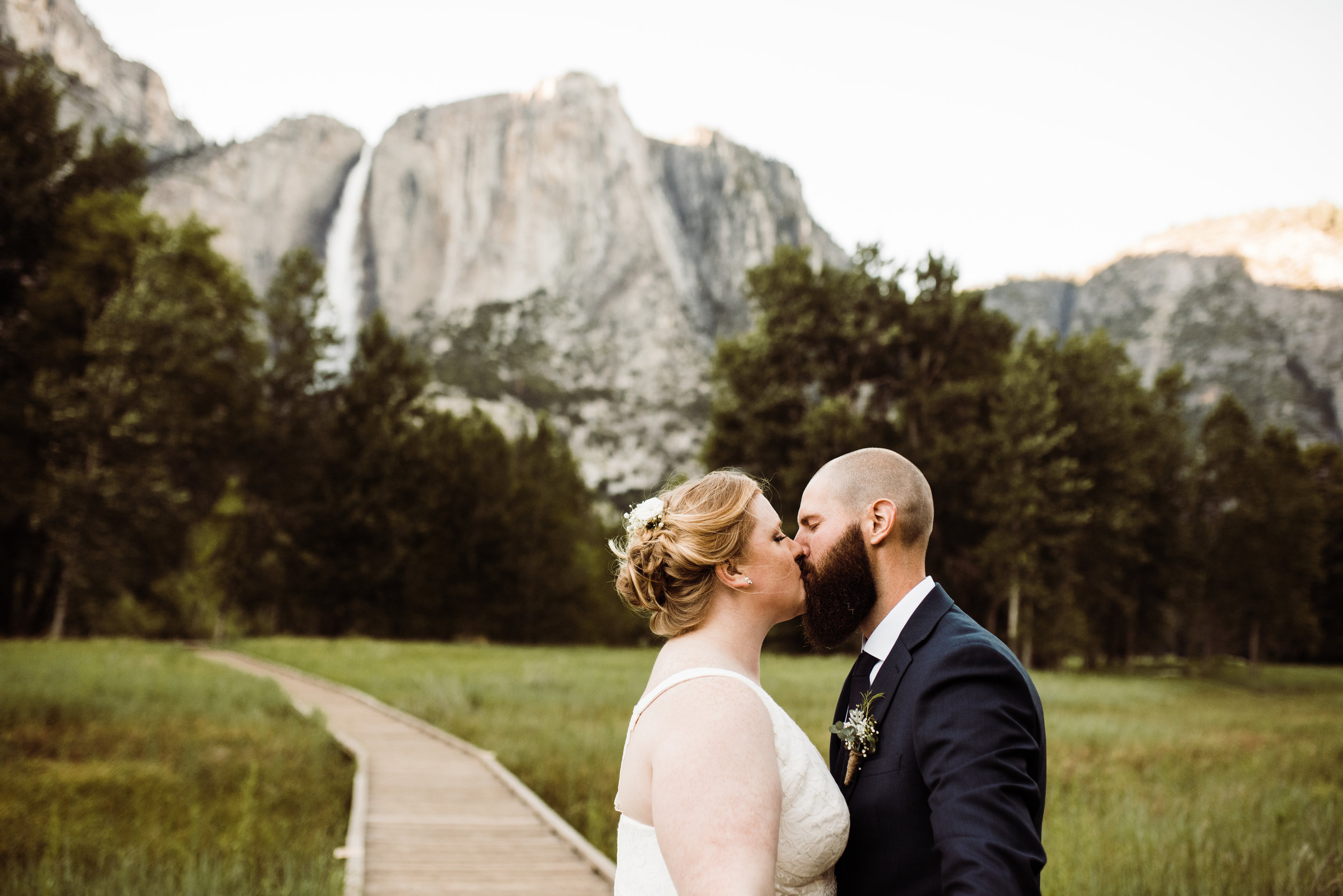 Elopement Couple Kissing beneath Yosemite Falls in Yosemite National Park