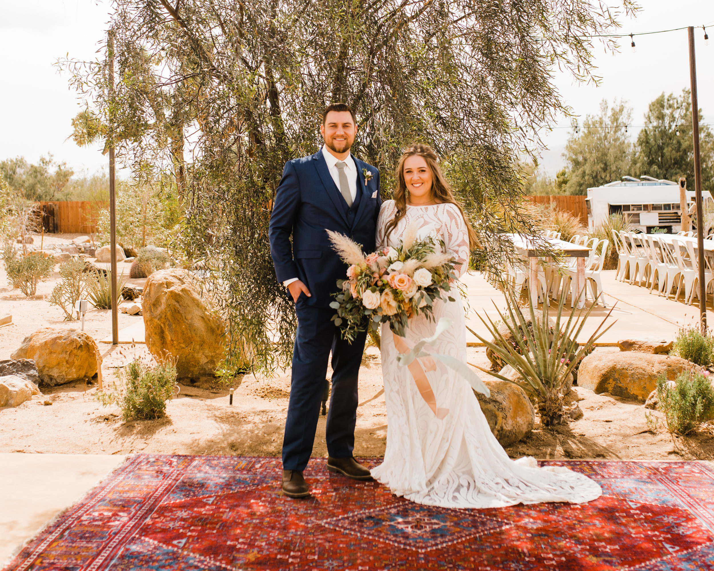 Bride and Groom pose for a portrait before the ceremony at Tumbleweed Sanctuary in Joshua Tree, California with desert-inspired boho florals