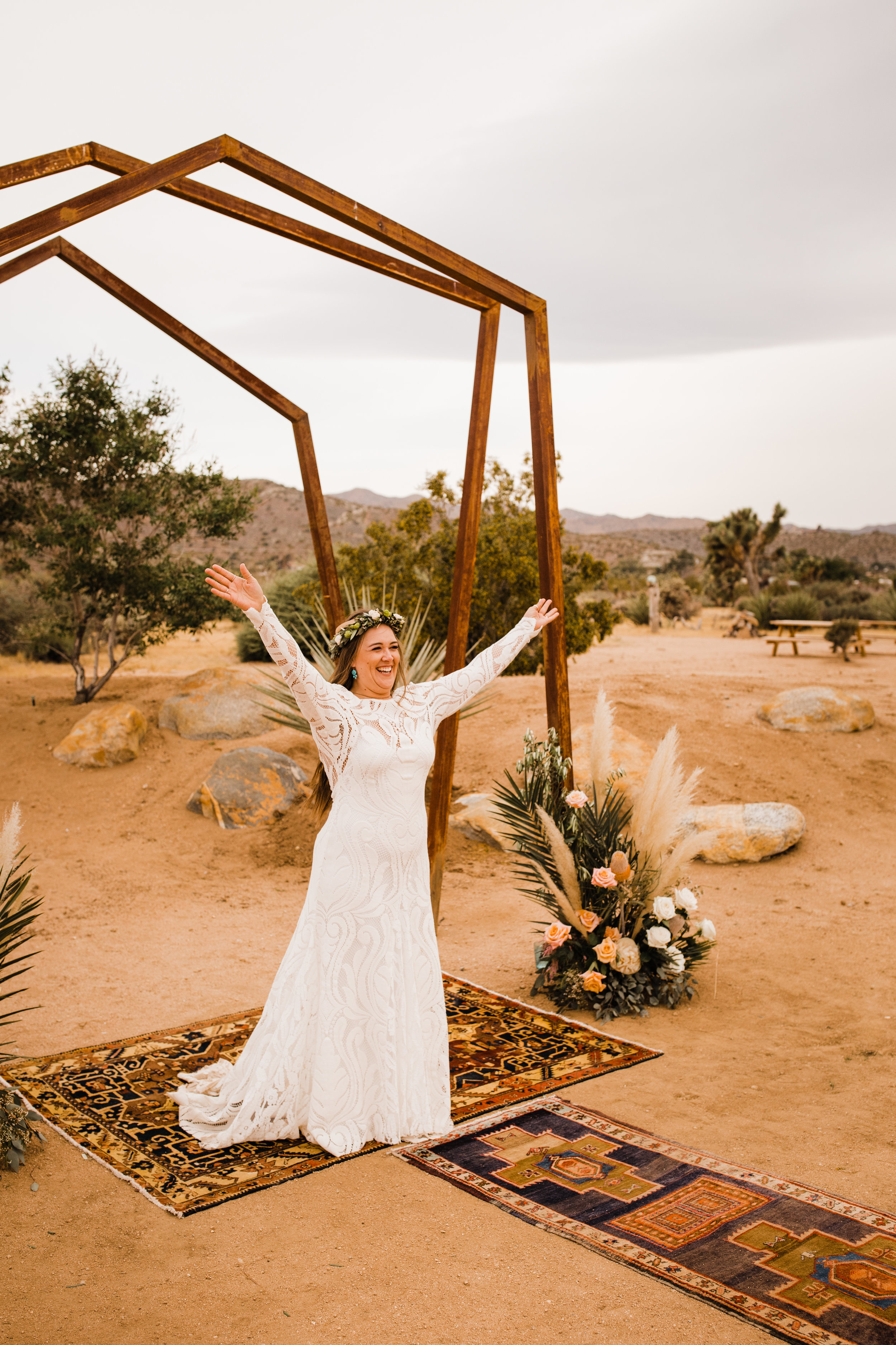 Excited bride beneath metal arch at Tumbleweed Sanctuary and Garden