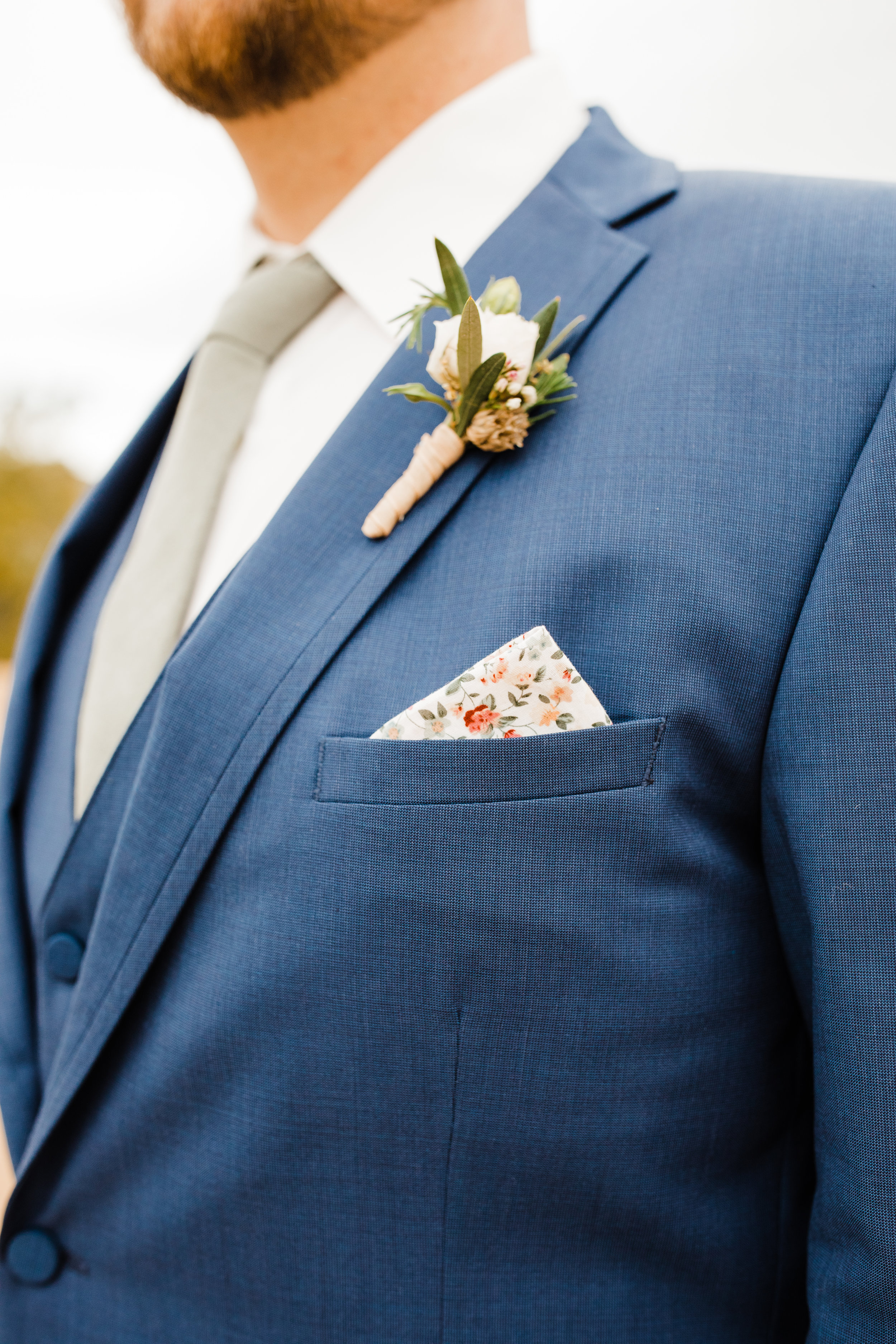 Groom's Floral Pocket Square Detail and Boutonniere. Blue Suit by Friar Tux and flowers by Pinyon Pine Floral Design.