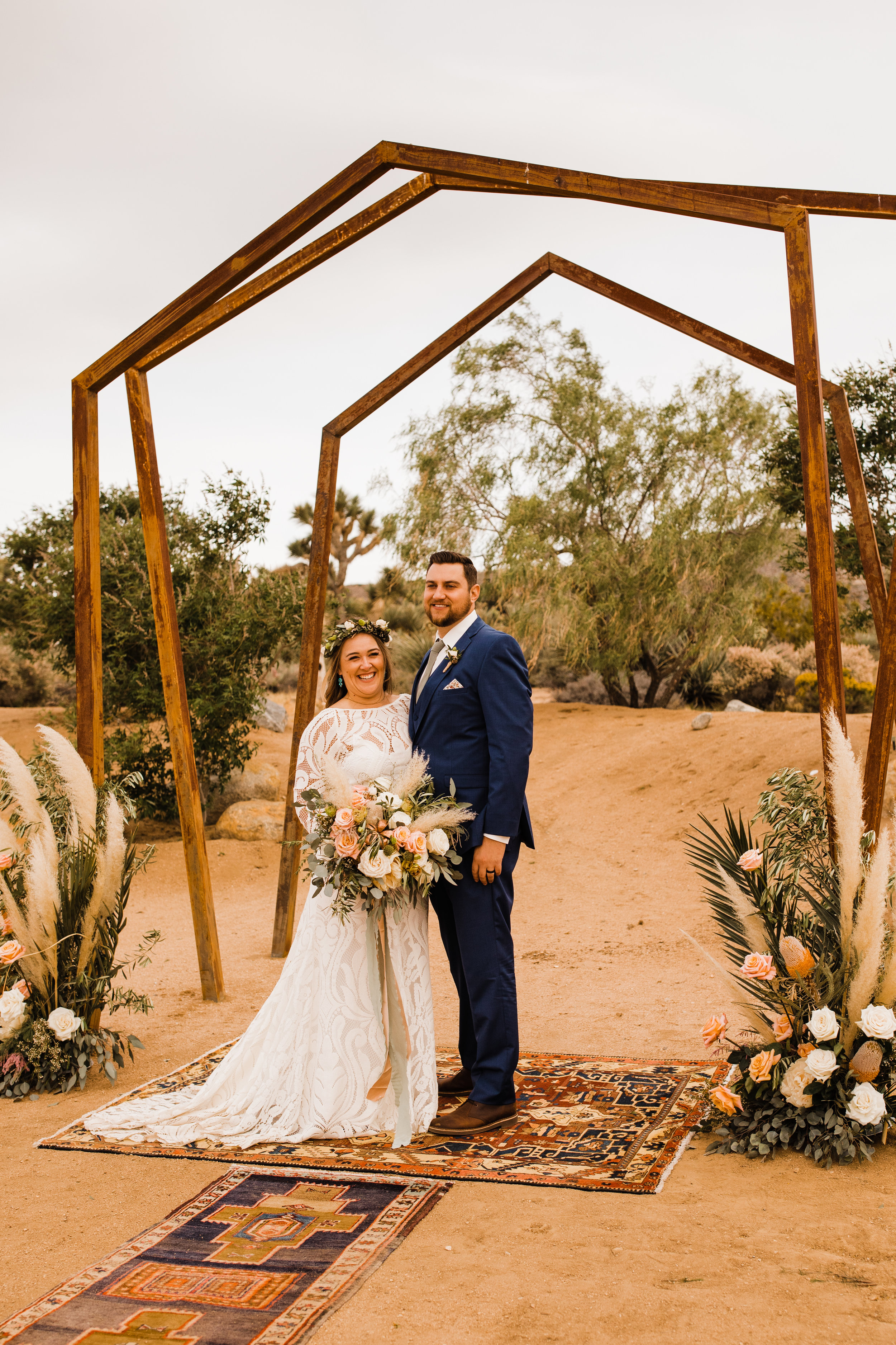 bride and groom beneath metal geometric arch at tumbleweed sanctuary wedding