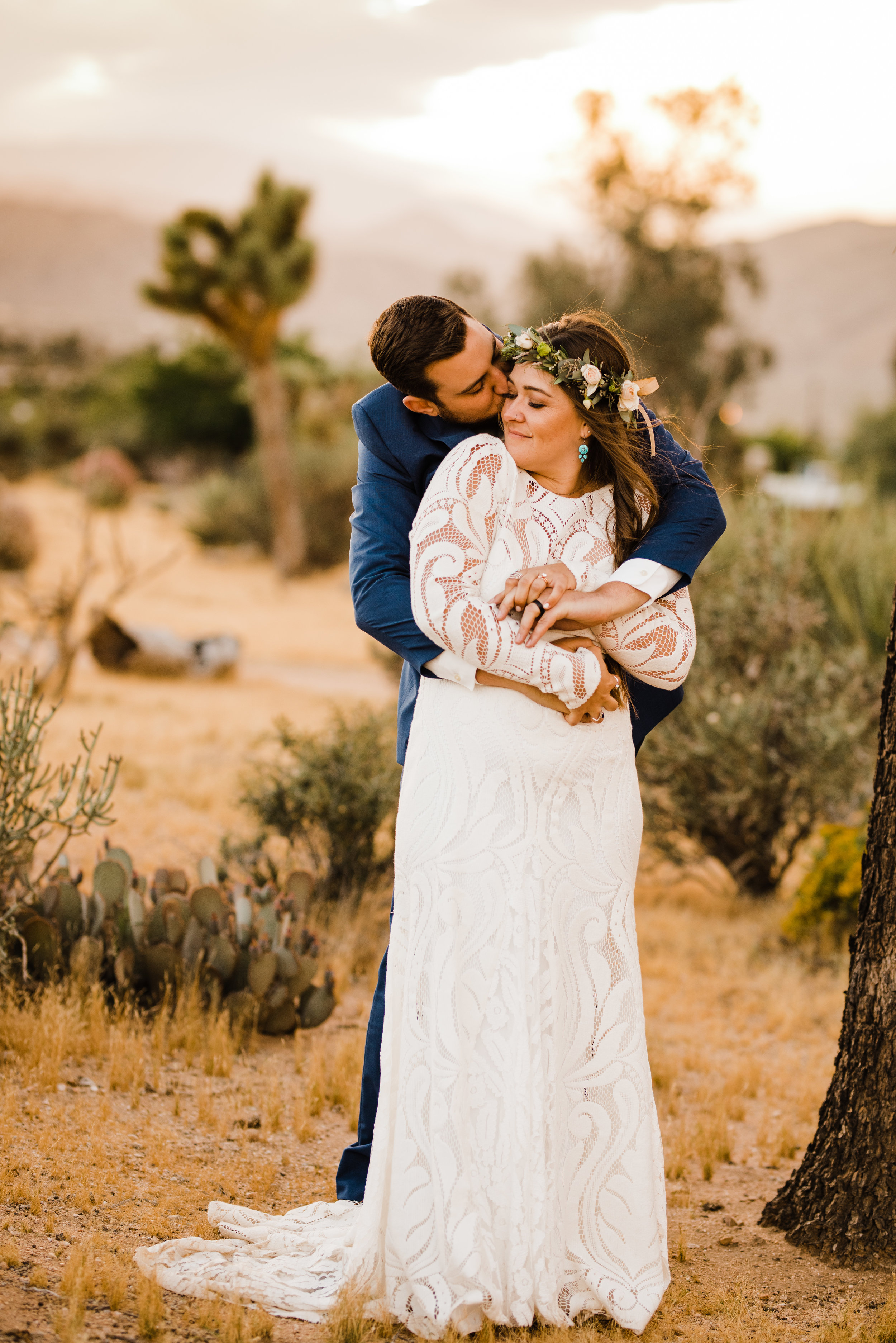 golden hour photo of bride and groom at tumbleweed sanctuary hugging - bride's dress by lovers society and groom wearing a suit by friar tux