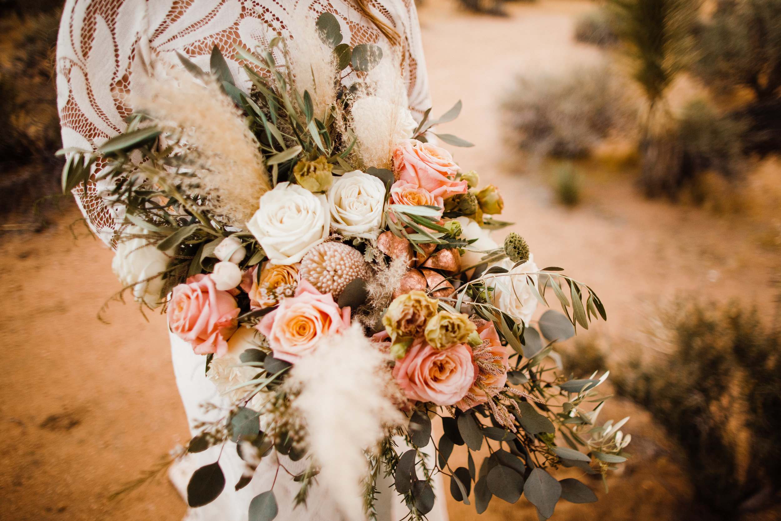 bridal bouquet of dried pampas grass, feathery elements and a copper rose mixed in with white and pink flowers